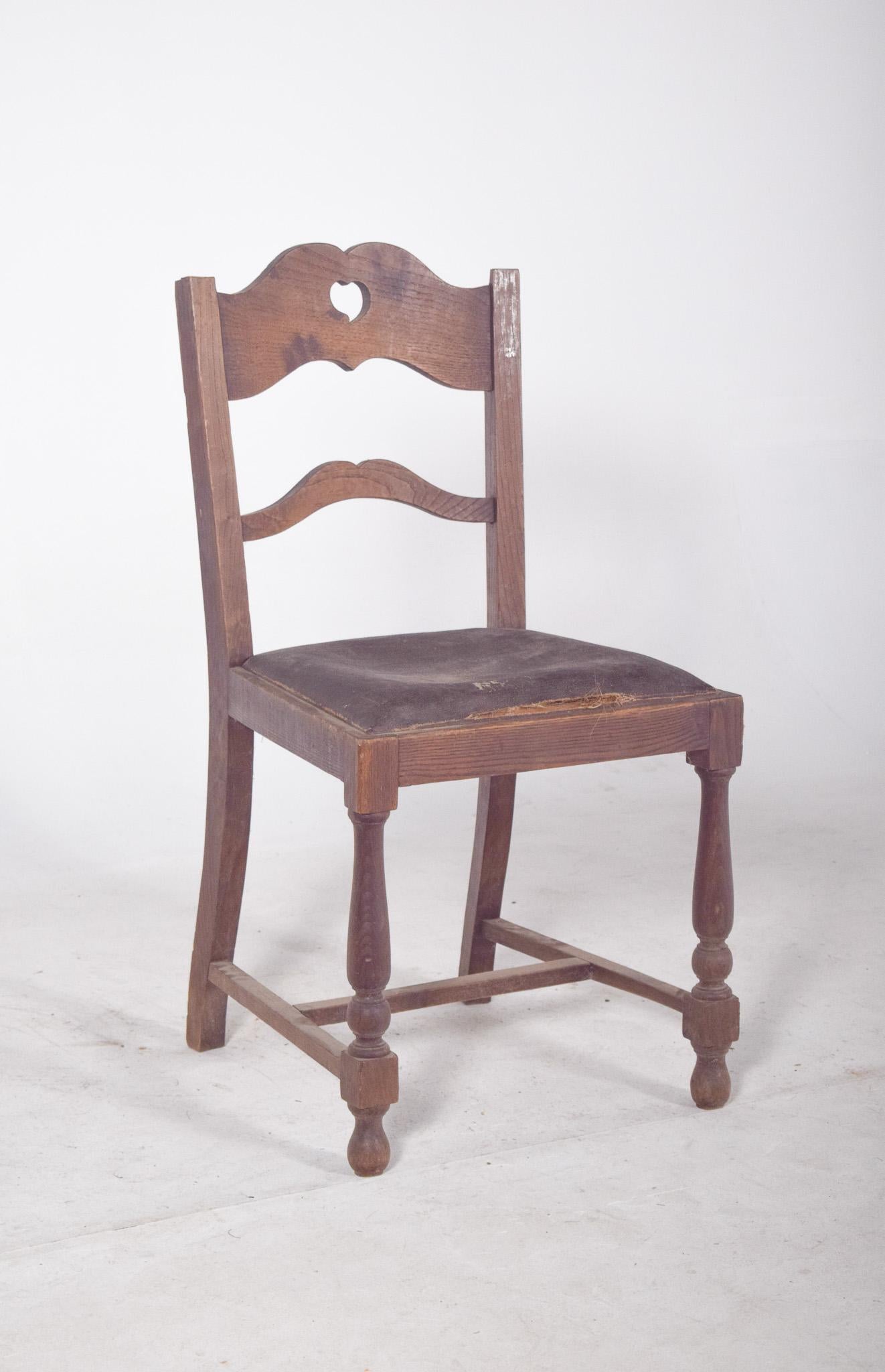 Rustic chair with a heart on the back. Traditional style, with a backrest made up of two horizontal, winding crossbars. The most characteristic detail of the piece is the heart-shaped cutout at the top of the backrest, giving it a rustic and