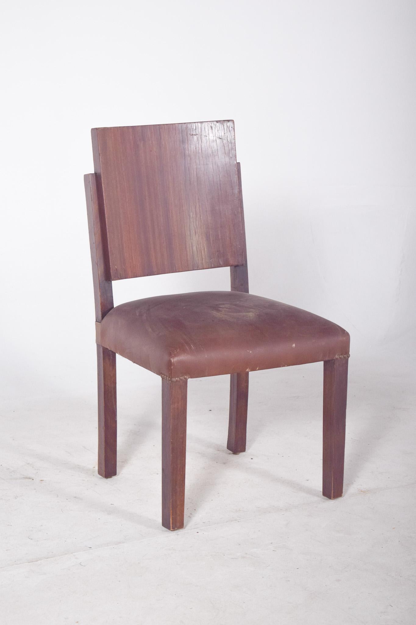 Sedia in legno dalle linee rette. Con un design semplice e contemporaneo, è realizzato in legno con uno schienale dritto in impiallacciatura di legno scuro, che mostra discreti segni di usura e piccole irregolarità naturali del materiale. La seduta
