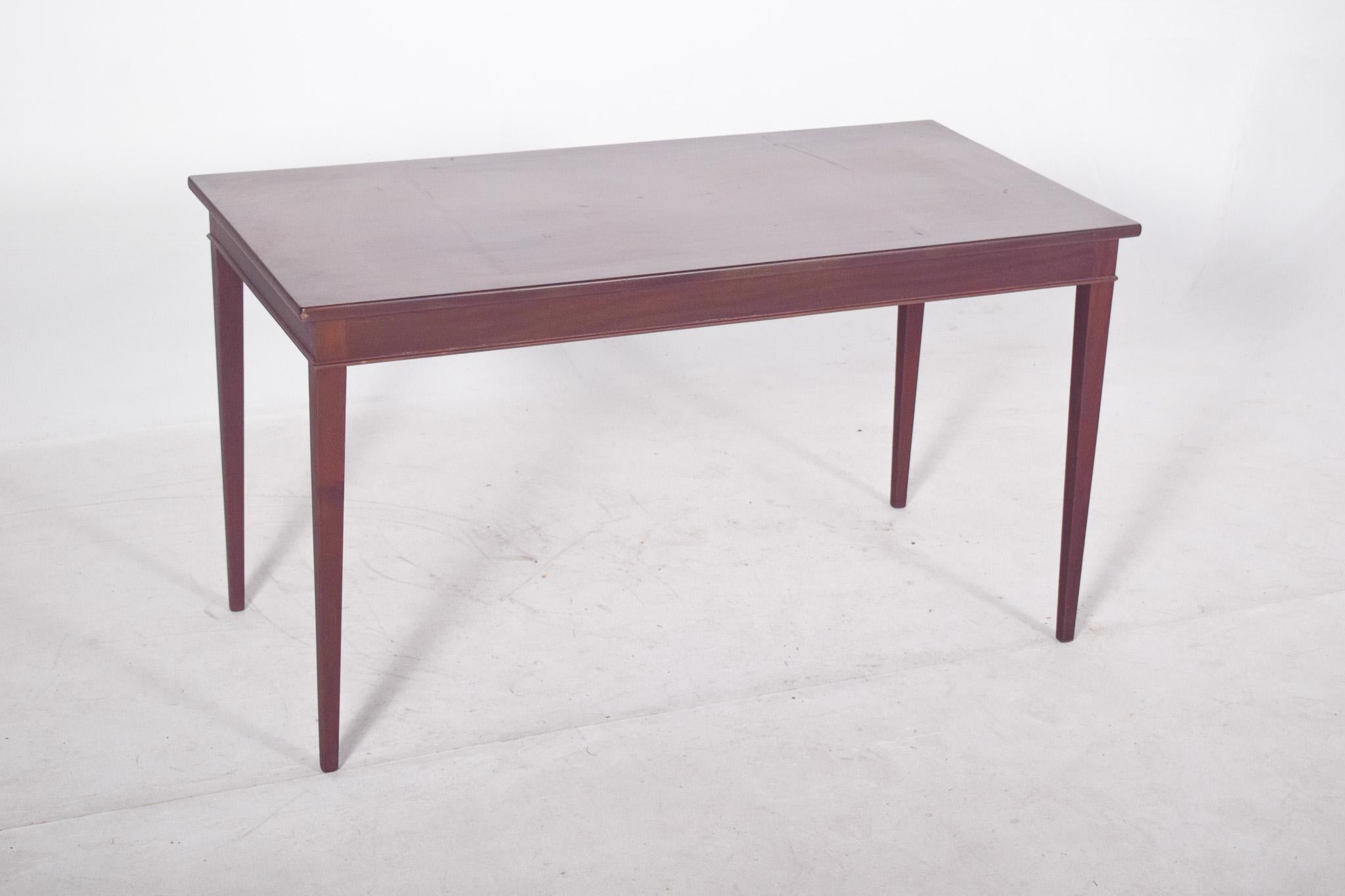 Rectangular coffee table, in mahogany. With a smooth top and a soberly designed structure, probably dating from the mid-20th century, the straight lines and lack of ornaments point to a functionalist or modernist style, typical of period furniture