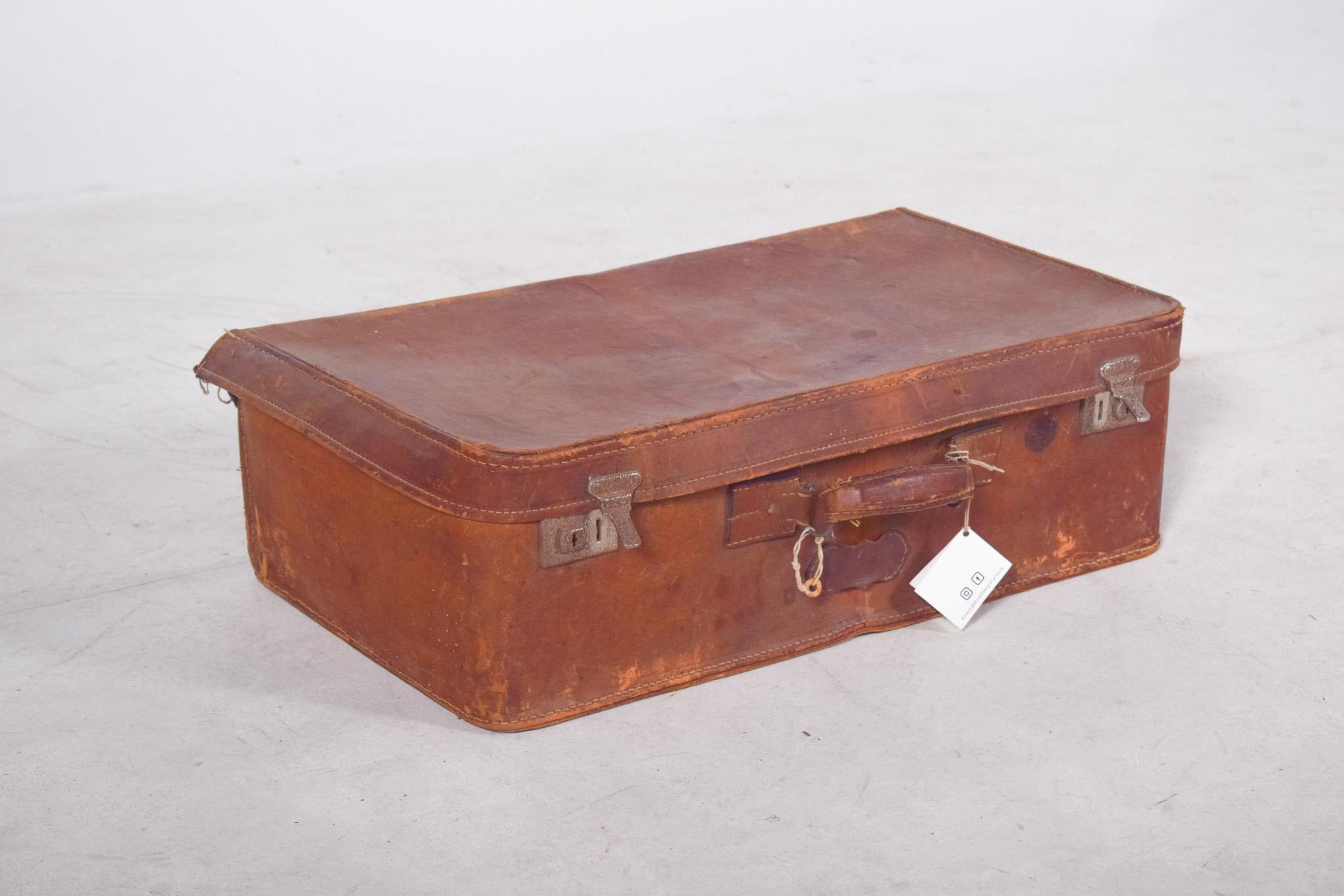 Borsa da viaggio in pelle. Di aspetto robusto, con evidenti segni d'uso, rivela una lunga storia di viaggi. La pelle presenta un'usura naturale, con piccoli difetti e scolorimenti che aggiungono carattere e autenticità. Le cerniere in metallo, con