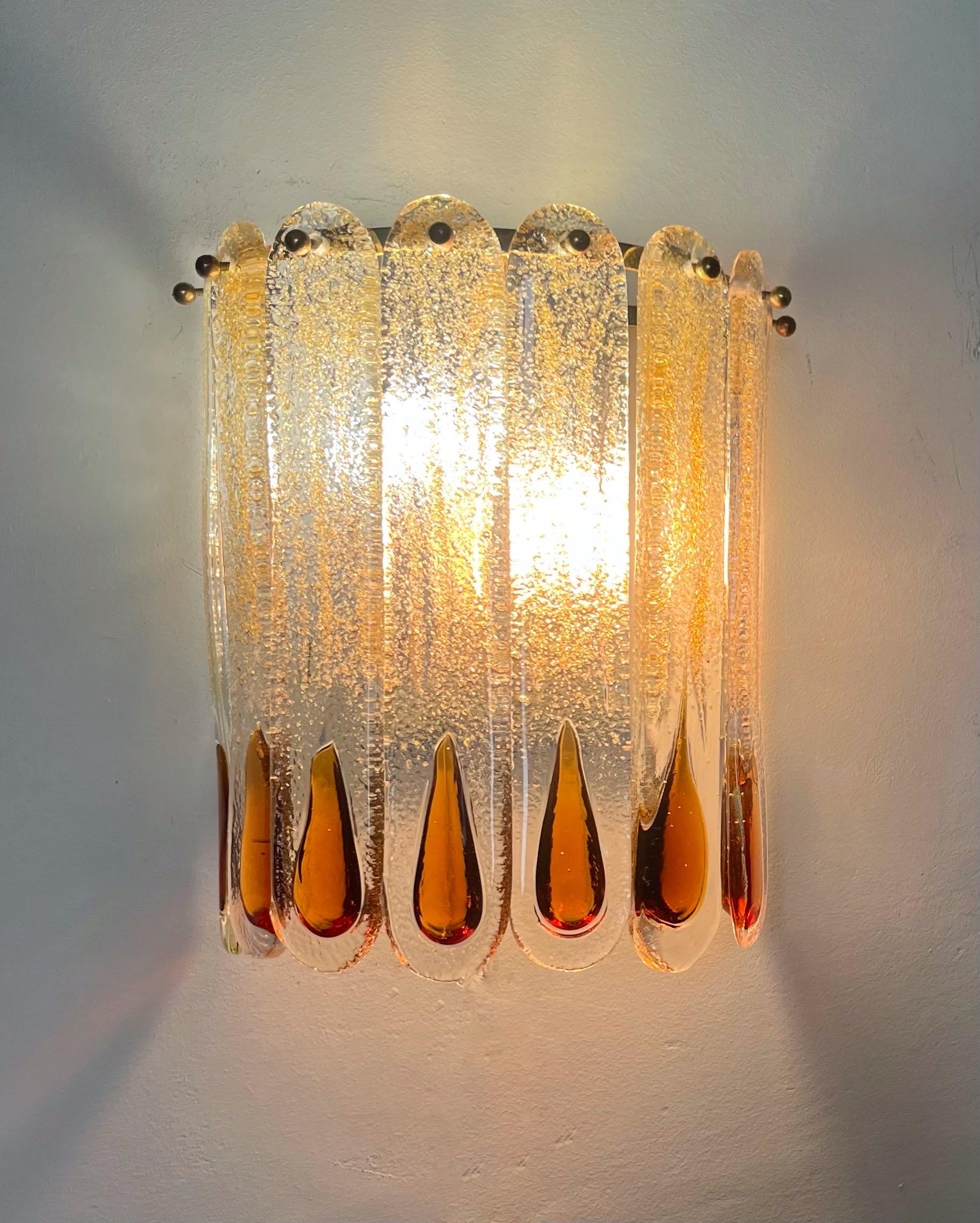 Stunning and beautiful Pair of Italian amber Murano glass Wall Sconces from 1970s.
These Wall Sconces were made during the 1970s in Italy for the Venice Company “Mazzega”.
Mazzega lie in the noble Venetian glassworking tradition; the firm was