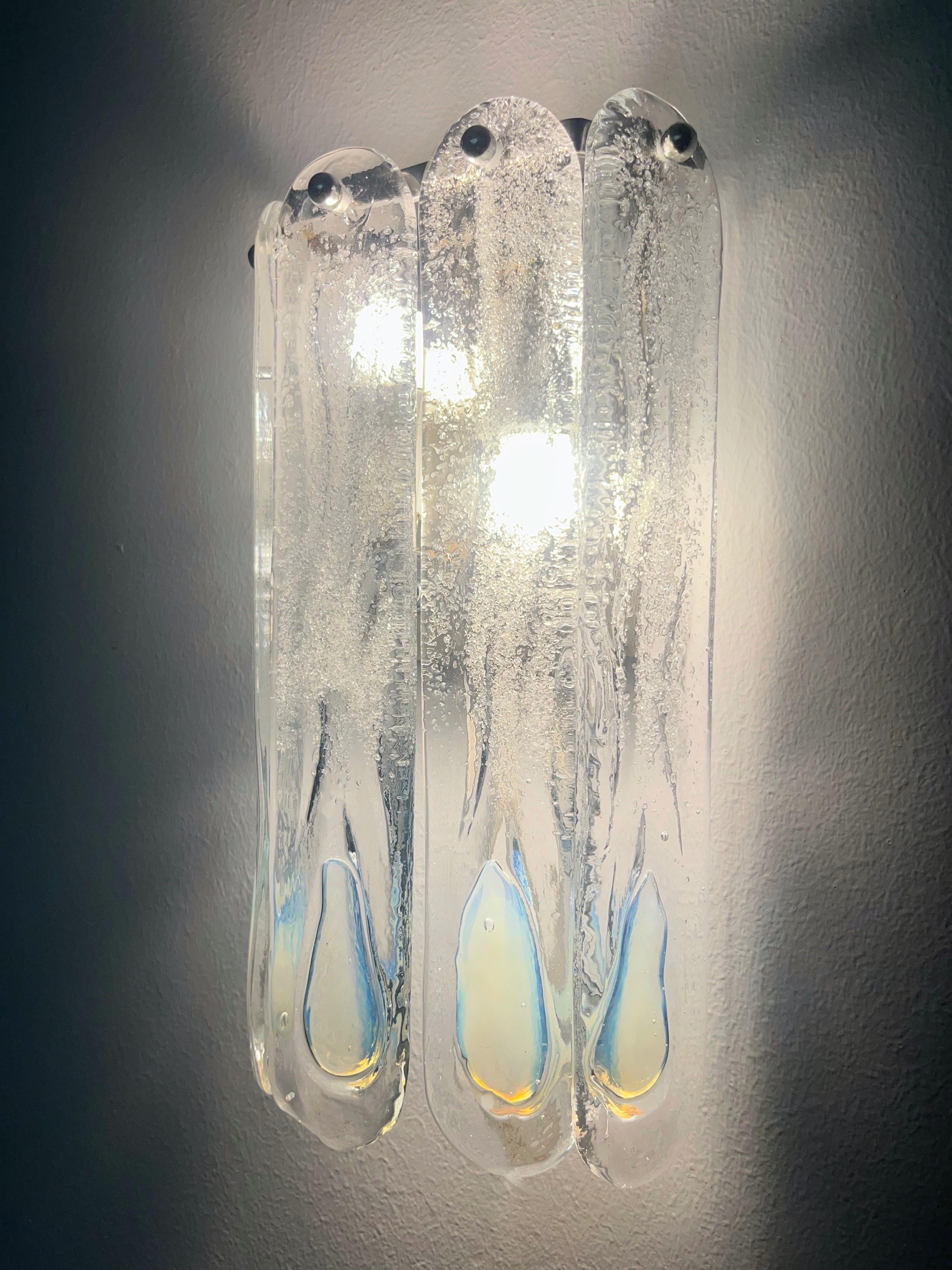 Stunning and beauty Set of Four Italian Iridescent White Clear Murano glass Wall Sconces. These fixtures were designed and manufactured during the 1970s in Italy by Mazzega.
Each Sconce is equipped with two light sockets E14. A professional