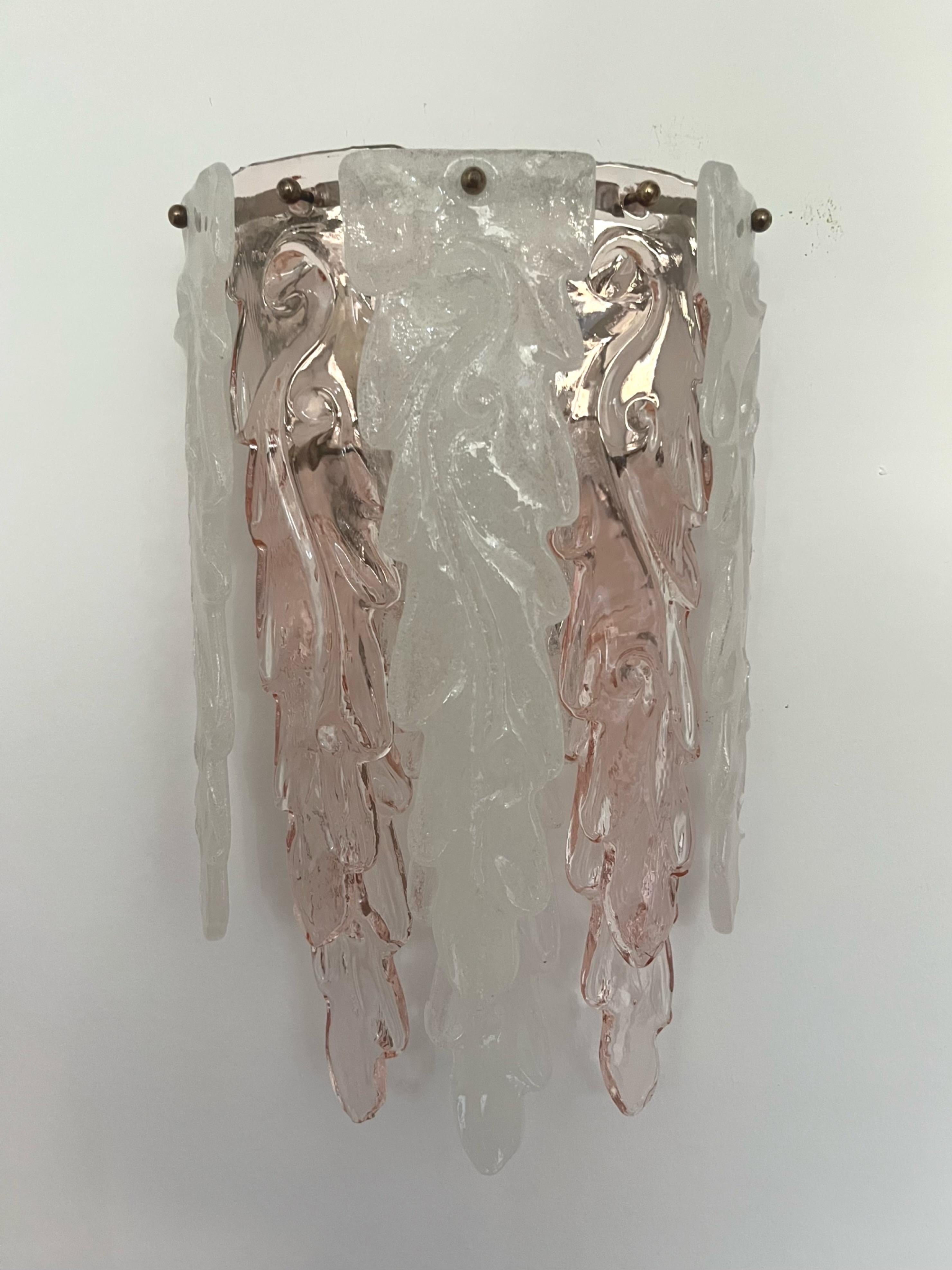 Hübsche, schöne und große italienische Wandleuchte aus klarem, rosa Murano-Glas aus den 1970er Jahren. Dieser Wandleuchter wurde in den 1970er Jahren in Italien von Mazzega entworfen und hergestellt.
Diese Leuchte besteht aus 8 langen, großen