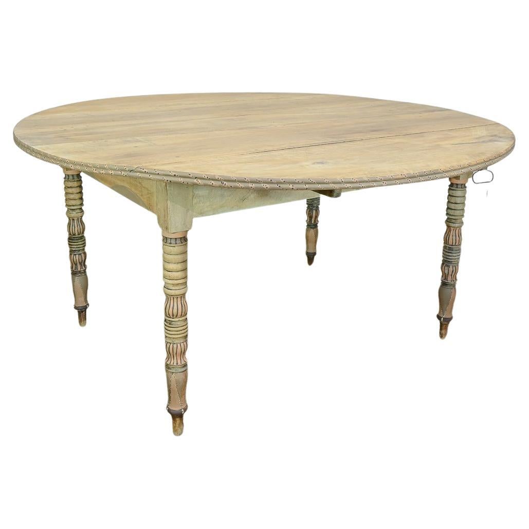 A charming provincial 19th Century French drop-leaf table. Constructed from chestnut, the raw bleached top displays five wide planks. The top demonstrated a double beaded lip around the edge, finished with charming painted repeated designs. Raised