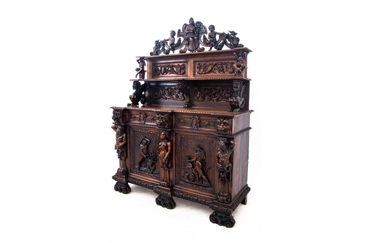 An old sideboard - chest of drawers with a top in the Renaissance style. Made in the late 18th century from walnut wood. A unique piece of furniture, richly decorated with carvings and reliefs. Very good condition.

Origin France,

Wood