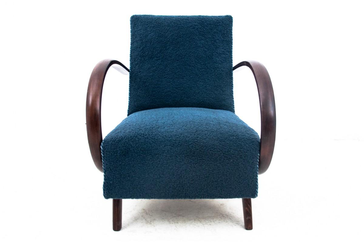 Fauteuil iconique conçu par J.Halabala dans le style Art Deco, réalisé vers 1930. Assise et dossier garnis de tissu bouclé bleu marine. L'ensemble repose sur des pieds droits, et les accoudoirs en bois courbé ajoutent du chic. Un fauteuil très
