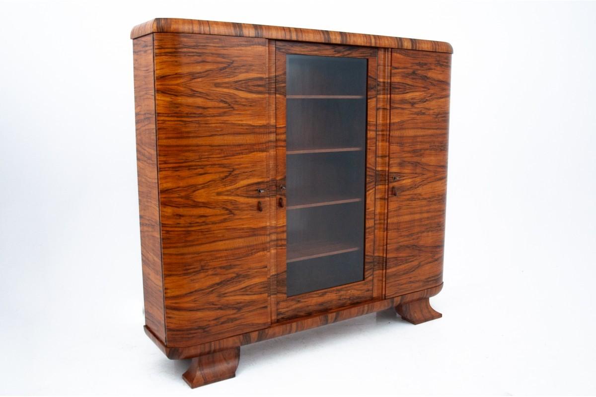 Libreria Art Deco in legno di noce, Polonia, anni '30.

Un mobile dalla forma geometrica, caratteristica dello stile Art Déco. La parte centrale è chiusa da una porta di vetro. Le parti laterali sono chiuse da una porta con chiave. All'interno ci