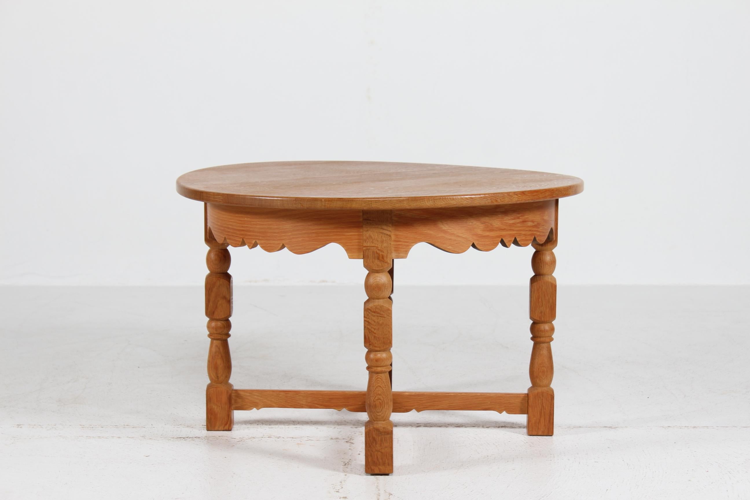Great Henning Kjærnulf style round coffee table of heavy solid oak
Brutalist style with carved legs and wavy table rim.
Handcrafted by a Danish cabinetmaker in the 1950s

Measures: Diameter 84 cm
Height 53.5 cm

The fine natural surface and patina