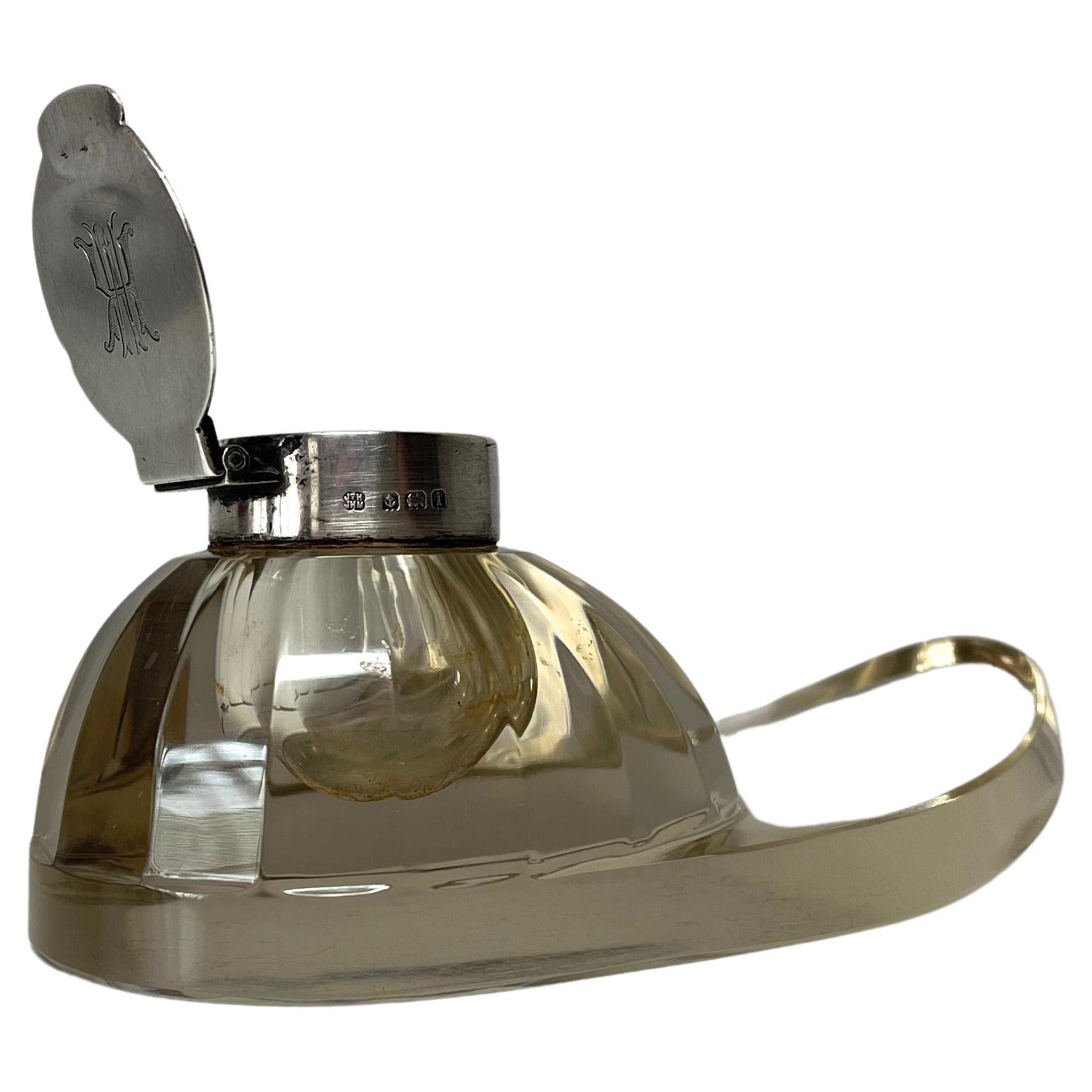 Edwardian cut glass jockey cap inkwell by Hukin & Heath, mounted on a hallmarked English silver collar.
Hinged collar with hallmark and engraved monogram cover
Hallmarked Birmingham 1908
Unusual and immensely collectible 
Length 5.5 inch, Height