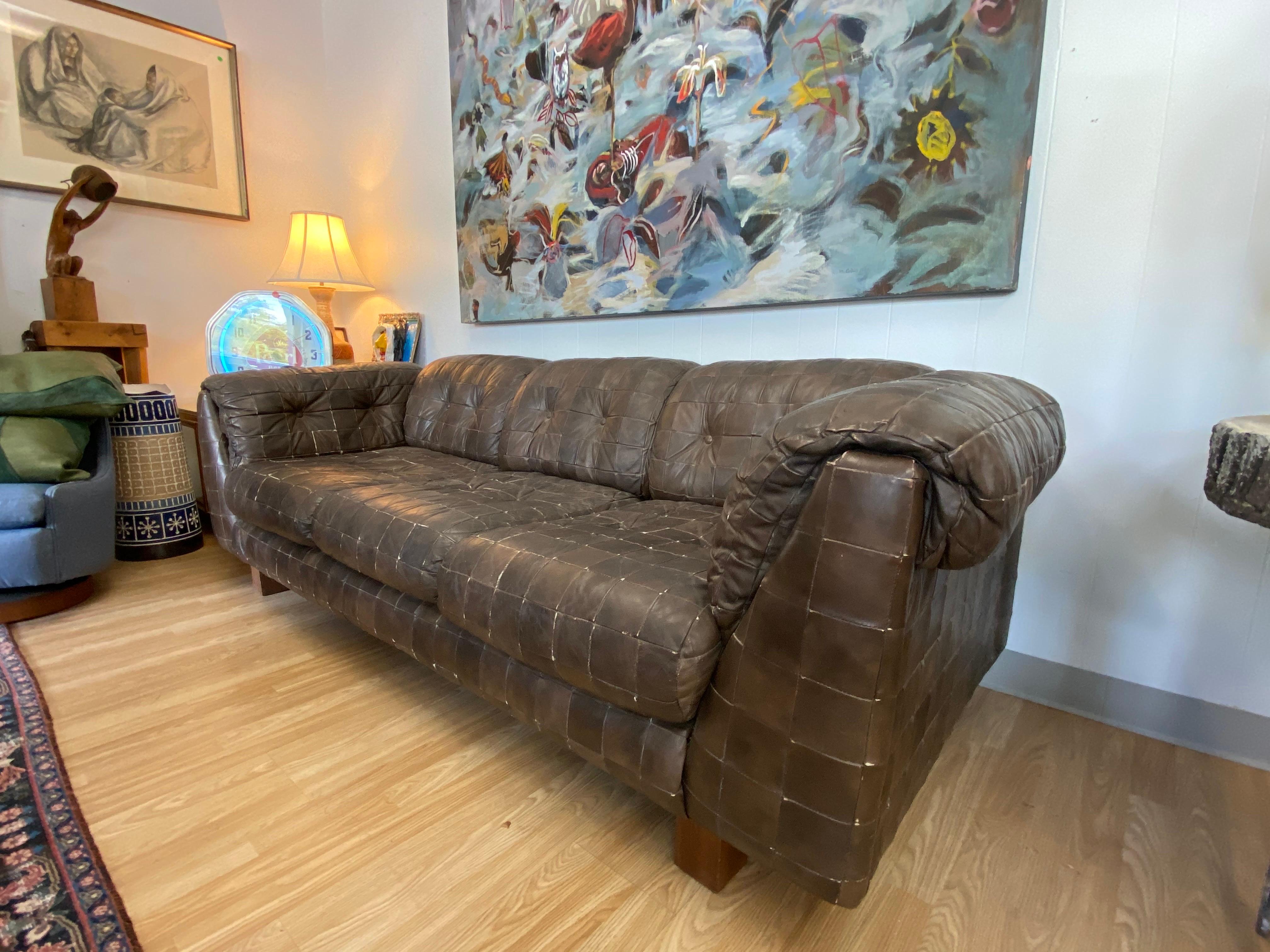 This vintage leather patchwork sofa is a warm brown color and is nicely worn and in good condition.