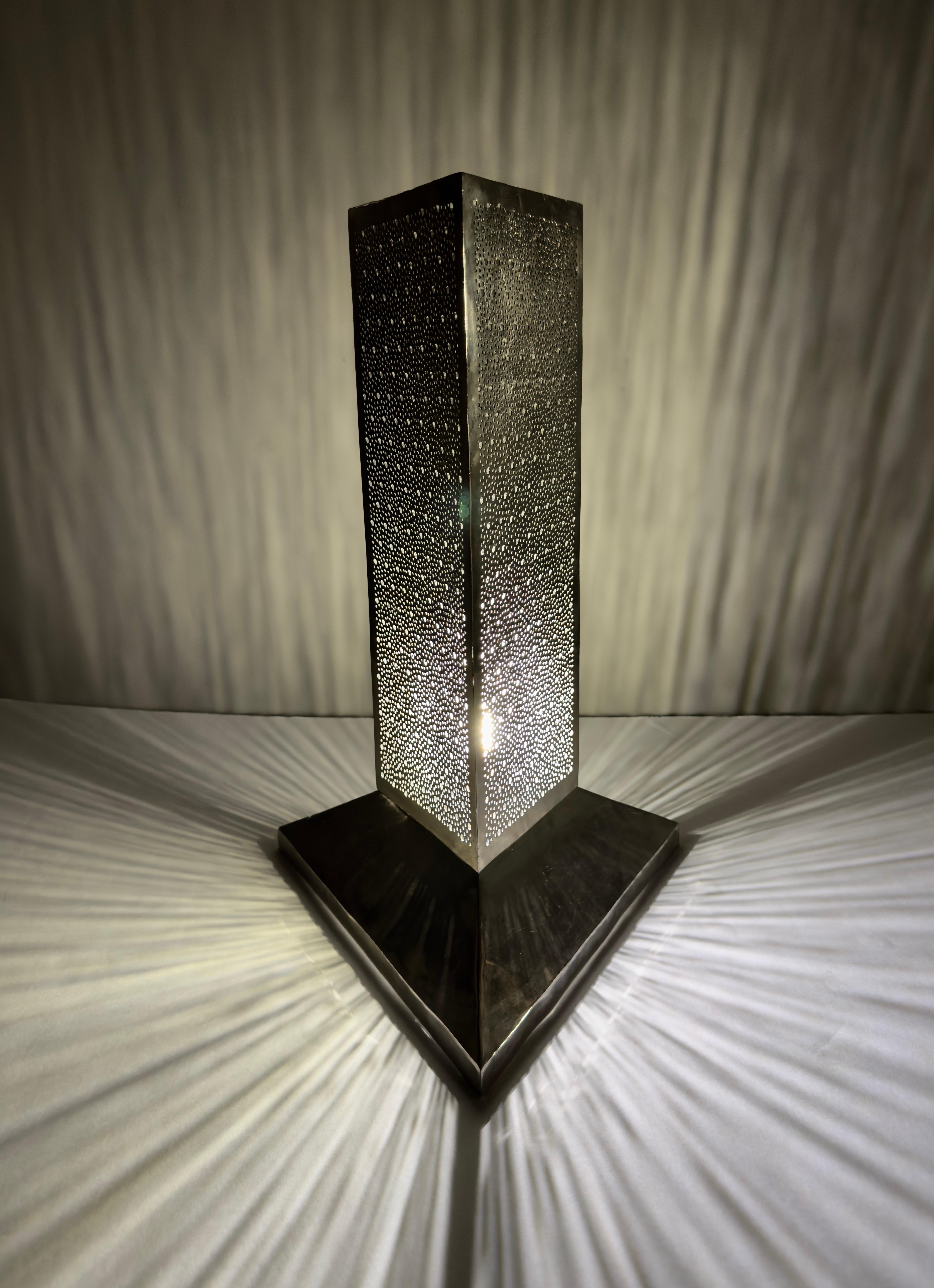 Une lampe haute et mince de style moderne du milieu du siècle, faite à la main. Avec ses dimensions triangulaires, cette lampe incarne l'essence de l'authenticité et de la sophistication. Chaque aspect de cette lampe est soigneusement fabriqué à la