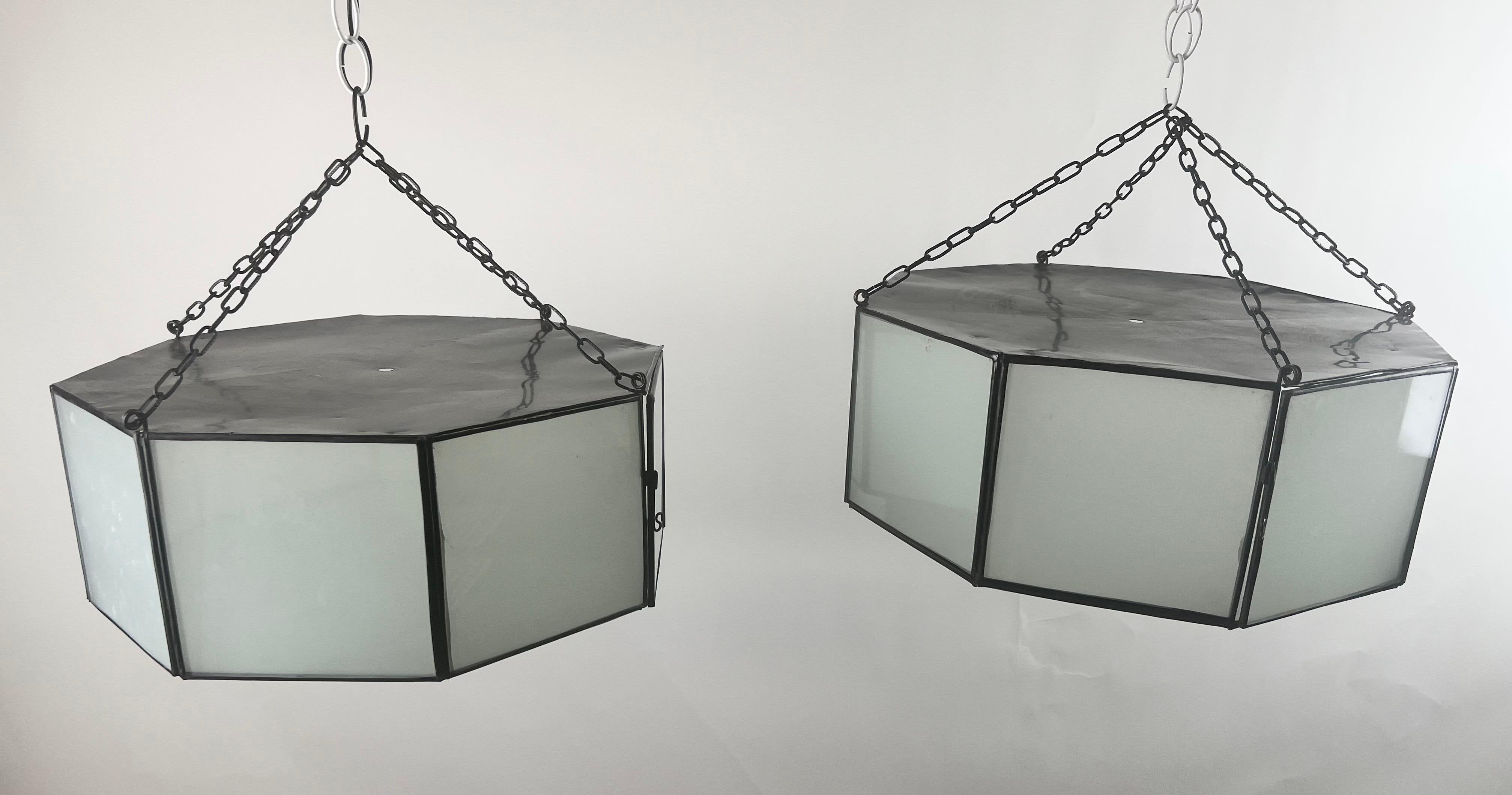 Ein Paar Pendelleuchten im Art-Deco-Stil, Laternen oder Unterputzleuchten. Die Pendelleuchten in stilvoller Achteckform werden in feiner Handarbeit aus einzelnen sandgestrahlten Milchglasscheiben und einem patinierten Bronzerahmen gefertigt. Die