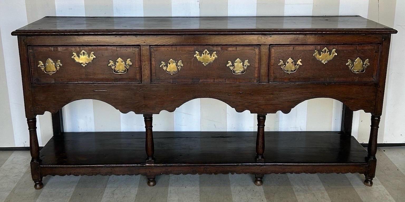 Grazioso comò gallese del XVIII-XIX secolo con cassettone. Questo pezzo è caratterizzato da cassetti a fasce incrociate, un'asse e gambe tornite. Con una profondità di 16