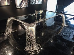 Table à manger sculpturale Cascatta en acier inoxydable poli miroir et verre