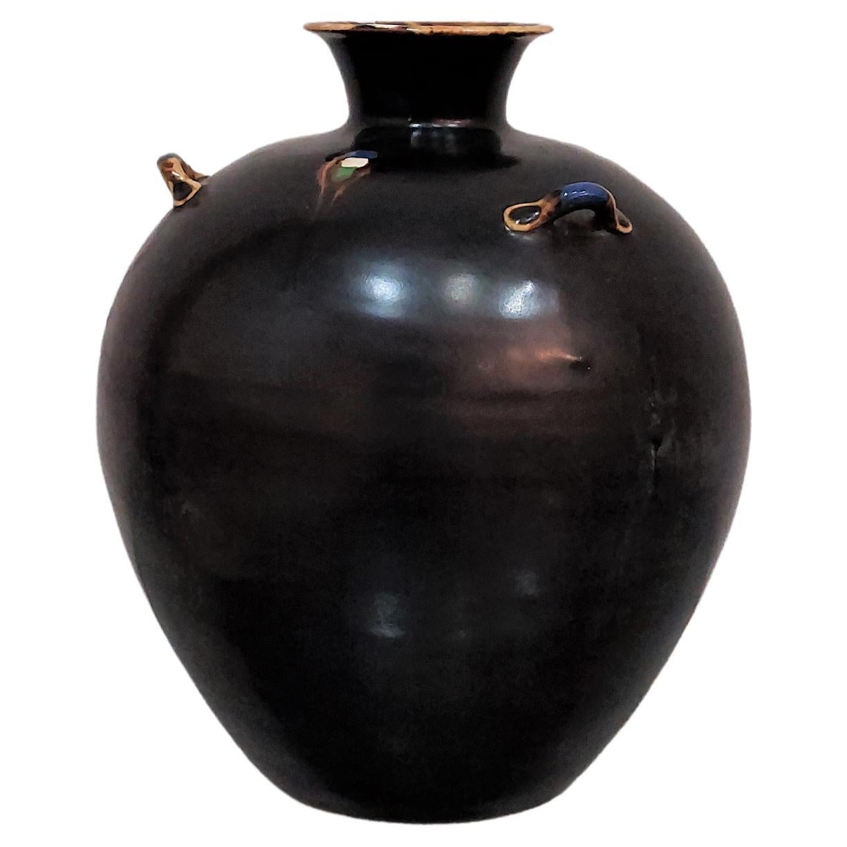 Vase in black enameled ceramic by an unknown designer with three small semicircular handles in polychrome glaze. It has a spherical body and a small neck with a flat edge where inside it is decorated entirely with polychrome enamel. Made in Italy in