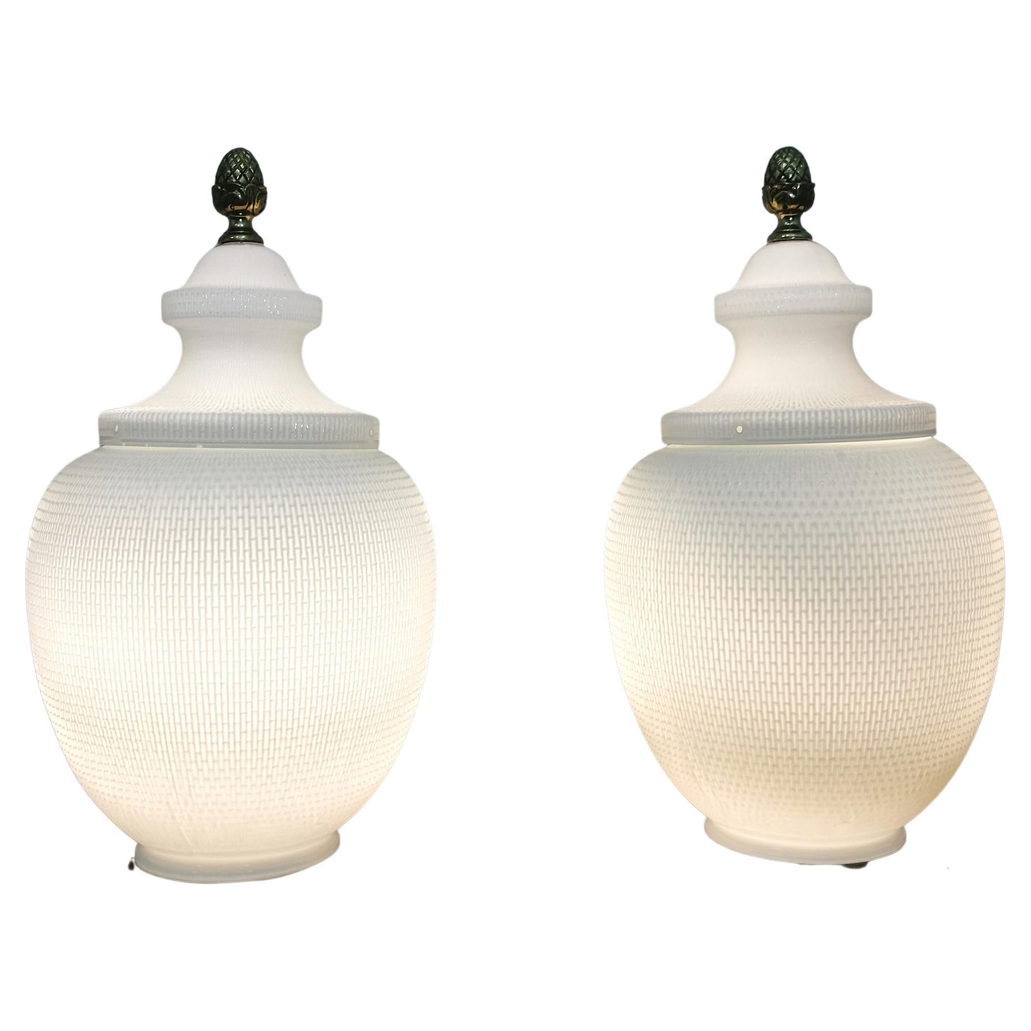 Rare and imponent pair of potiche table lamps produced in Italy in the 1980s. Each single lamp has a square-shaped base in enamelled wood that supports a large bowl with a lid made with a particular workmanship in white coated Murano glass. Brass