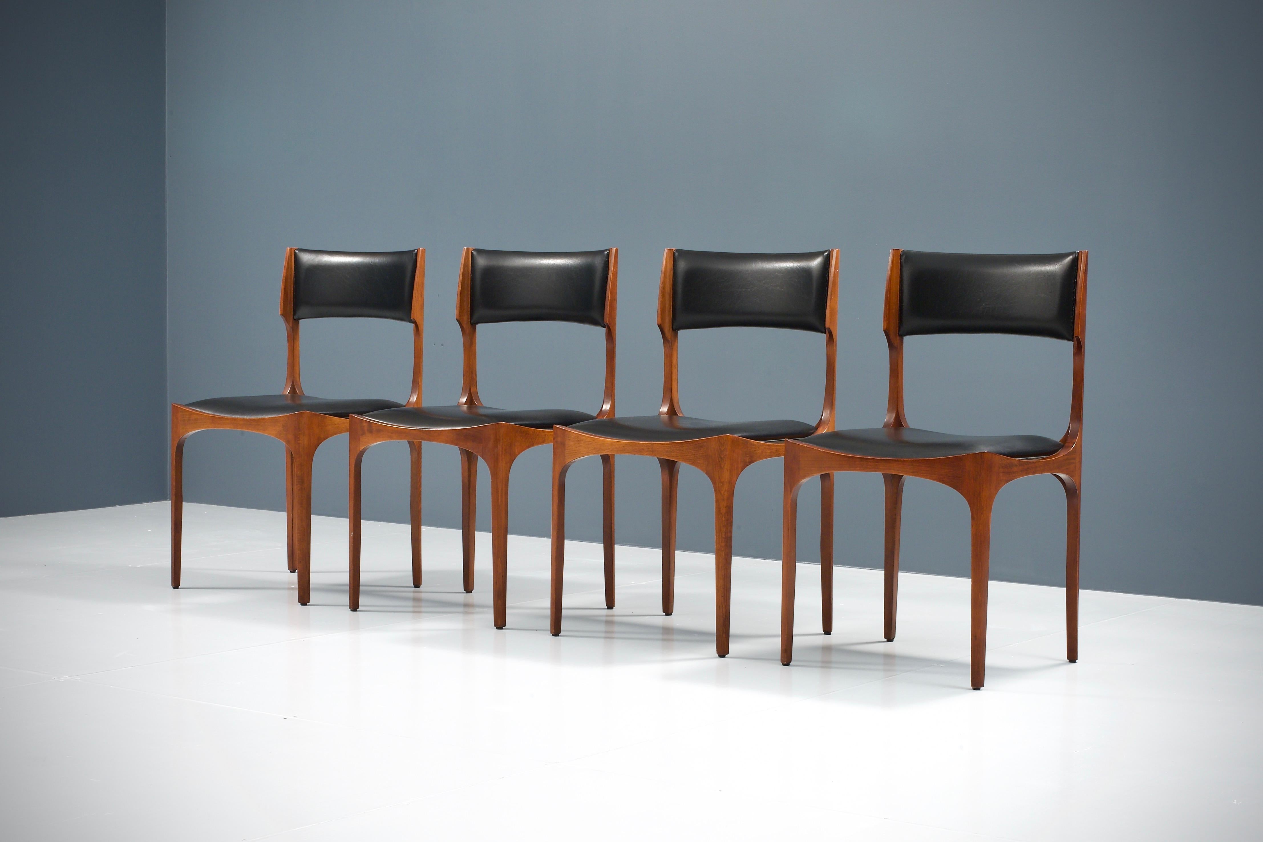 Set of four 'Elisabetta' dining chairs in beautifully patinated oak and faux leather by Giuseppe Gibelli for Fratelli Maspero, Italy, 1961, all in very good condition. The shapes of these chairs are quite distinct with its rounded forms and sharp