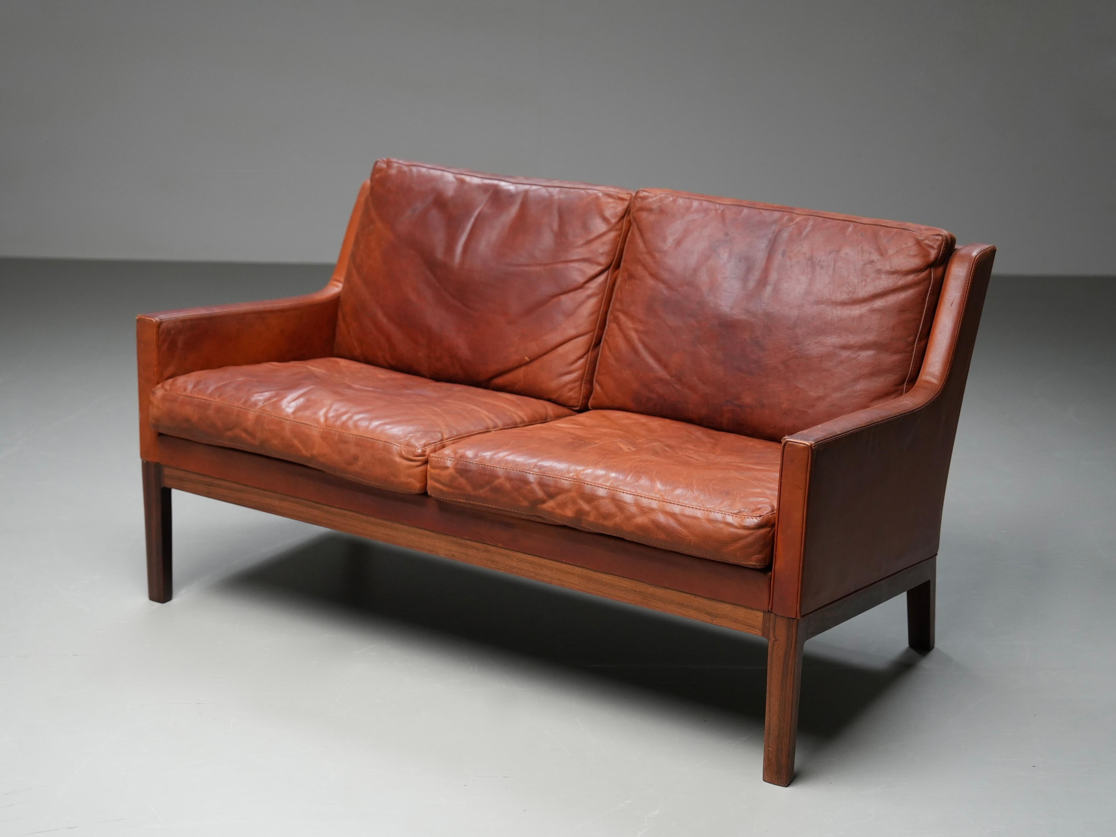 Loveseat by Kai Lyngfeldt Larsen in Cognac Leather and Solid Rosewood, 1960's

A rare and characterful loveseat by Danish designer Kai Lyngfeldt Larsen, upholstered in its original cognac leather. The leather has aged beautifully—still in one piece,