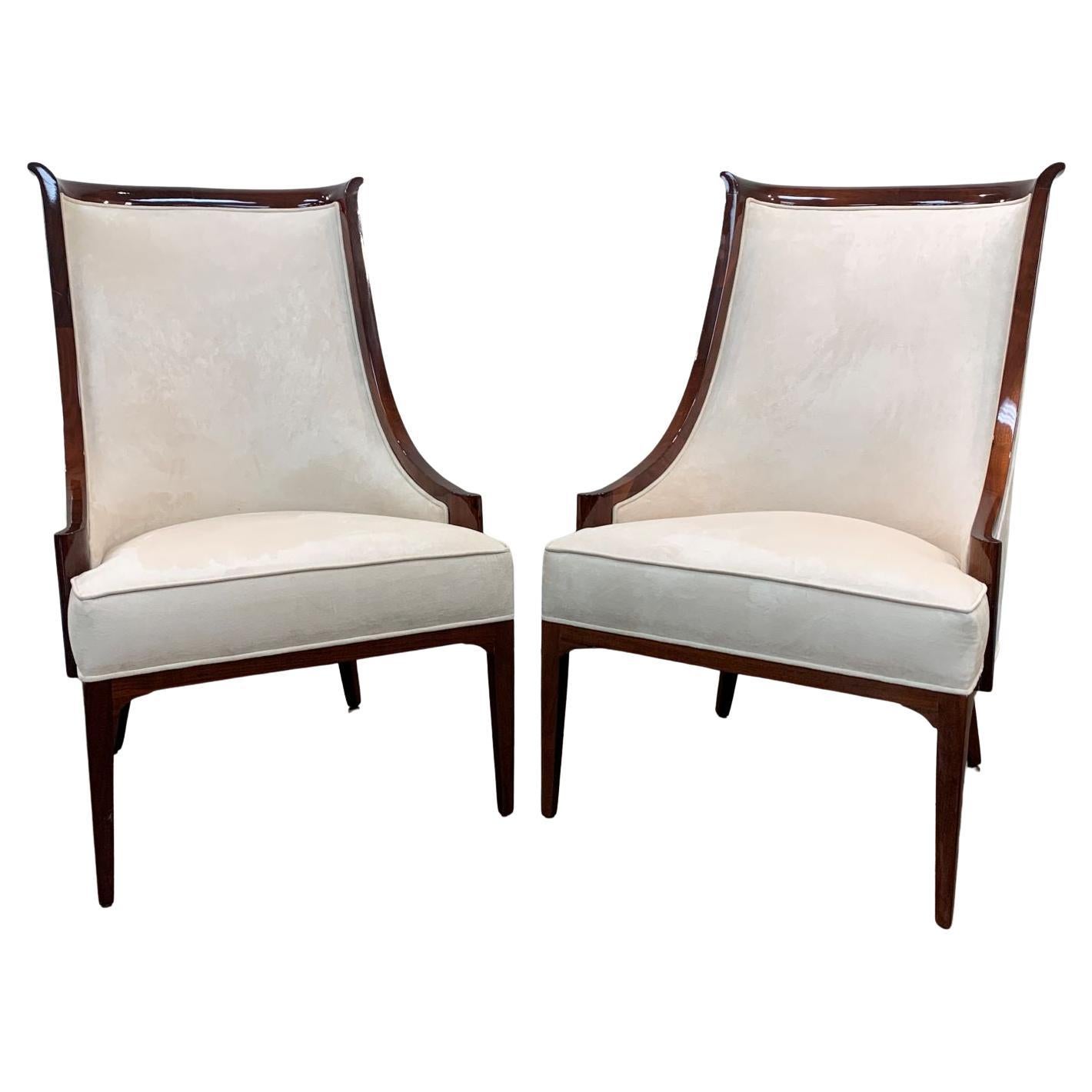 Pair of tall sculptural American Mid-Century Modern lounge chairs. Elegantly restored and handcrafted solid walnut in a gloss finish perfectly complimented with soft, cream ultra-suede upholstery. Measures: Height 37.5, width 24.5, depth 28, seat