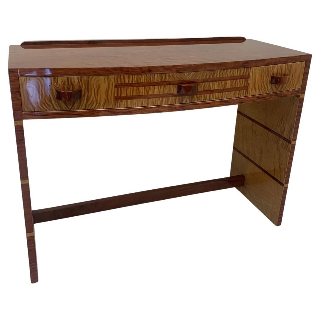 Extremely rare American Art Deco desk or wall console. This incredible desk has reverse wood inlays on different planes. Very unusual woods from curly maple to the characteristics of figured white Peroba. The three drawers provide ample storage.