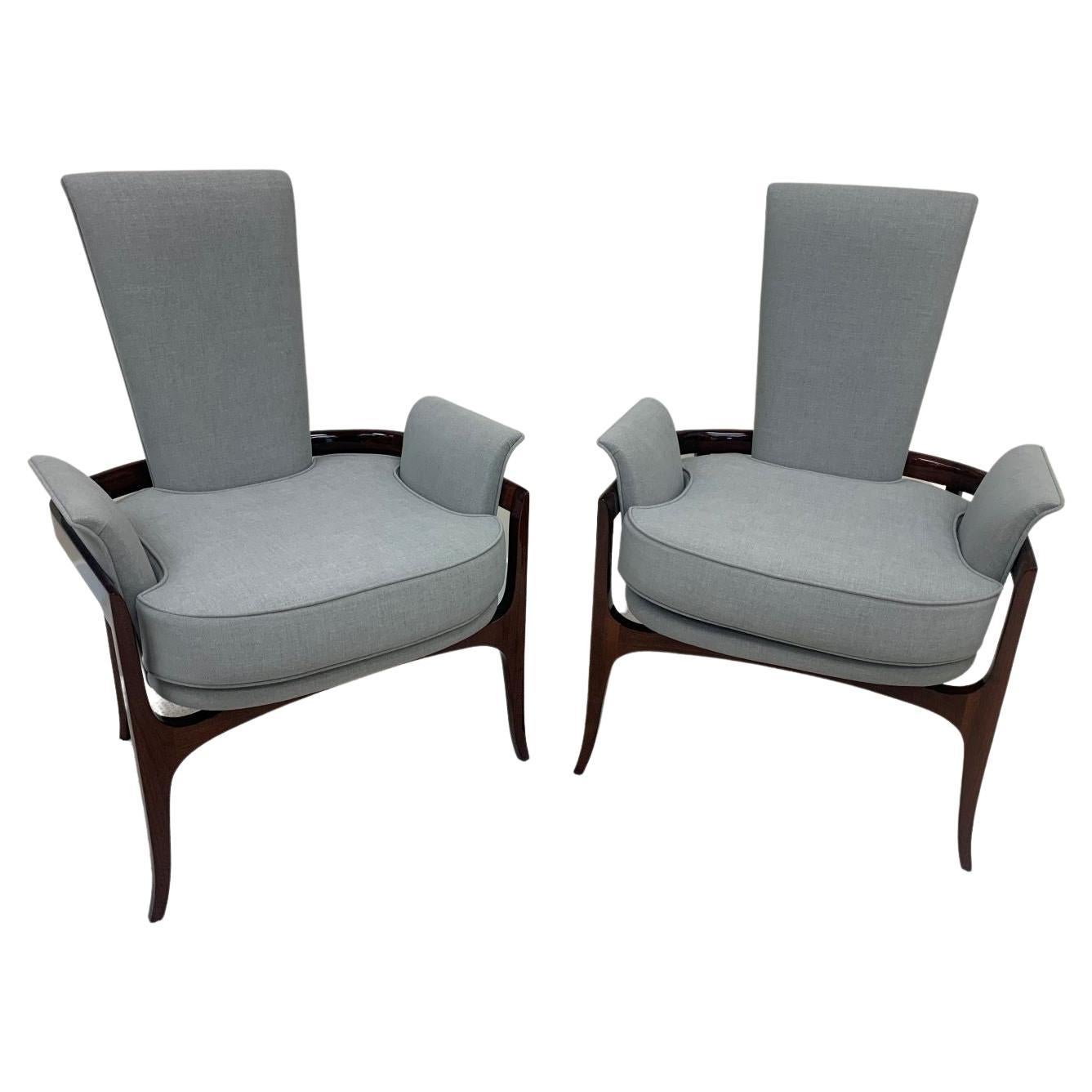 Mid-Century Modern sculptural pair of lounge chairs in the style of James Mont. Incredible design with the gentle curving upholstered arms and back that are wrapped in a solid walnut frame. Beautifully restored in a gray linen fabric with a gloss