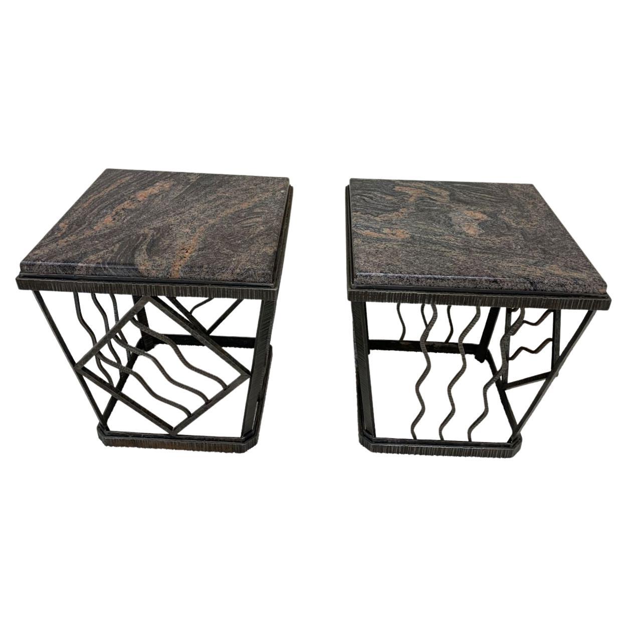 Pair of beautifully crafted Art Deco tables in the style of Oscar Bach. The bases are designed with an intricate iron pattern and with an elegant taper. Beautifully adorned with polished gray and earth tone marble tops. The tables are signed C.