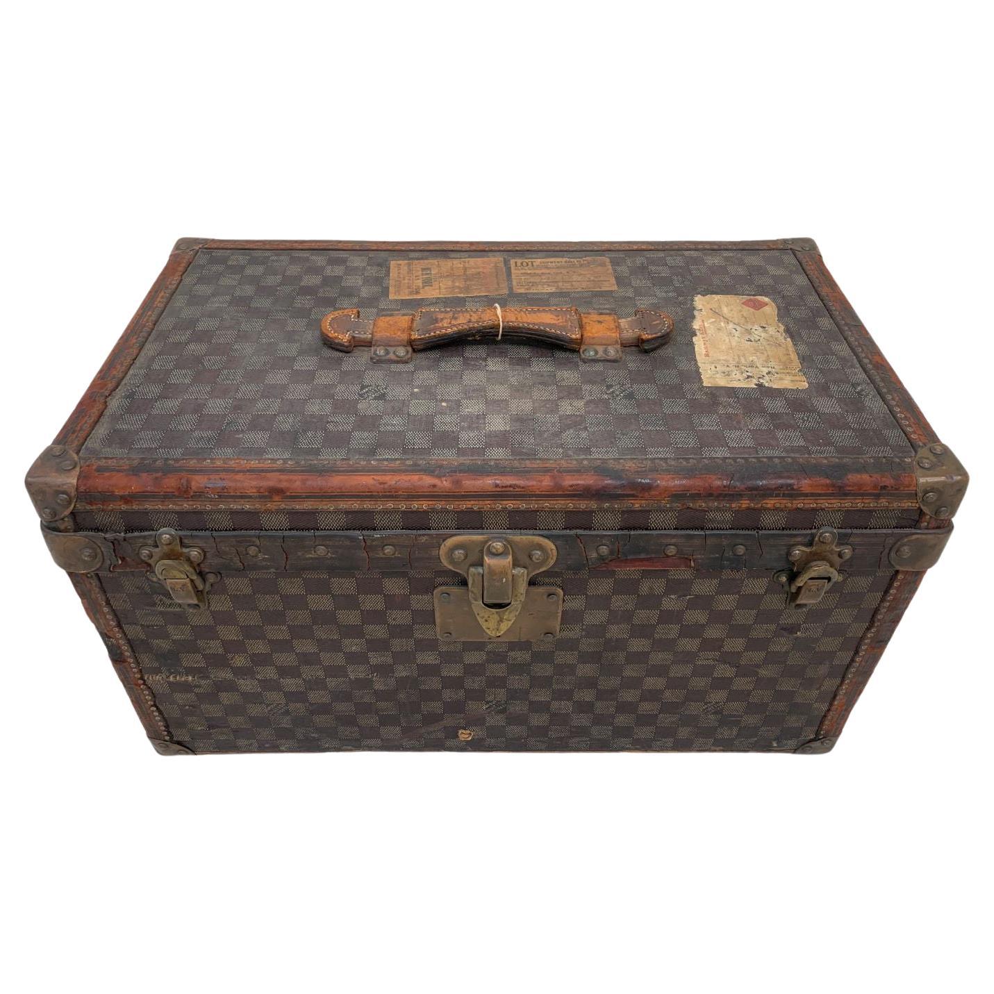 A rare Louis Vuitton Damier canvas trunk with leather trim and original brass fittings; circa 1890. A remarkable example of a hard-to-find size. Brand tag on the internal side of the cover reads, 