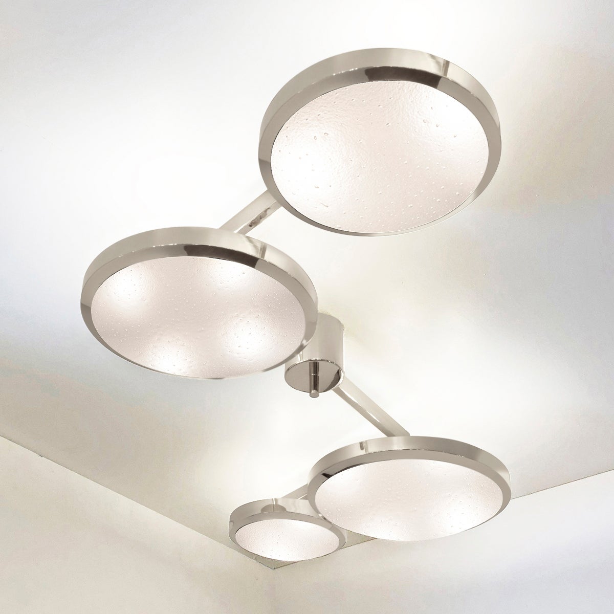 The Quattro ceiling light plays with the notion of lines and shapes, bringing the concept to life with its distinctive winding frame with four variable size shades at staggered heights. The first images show the fixture in our polished nickel