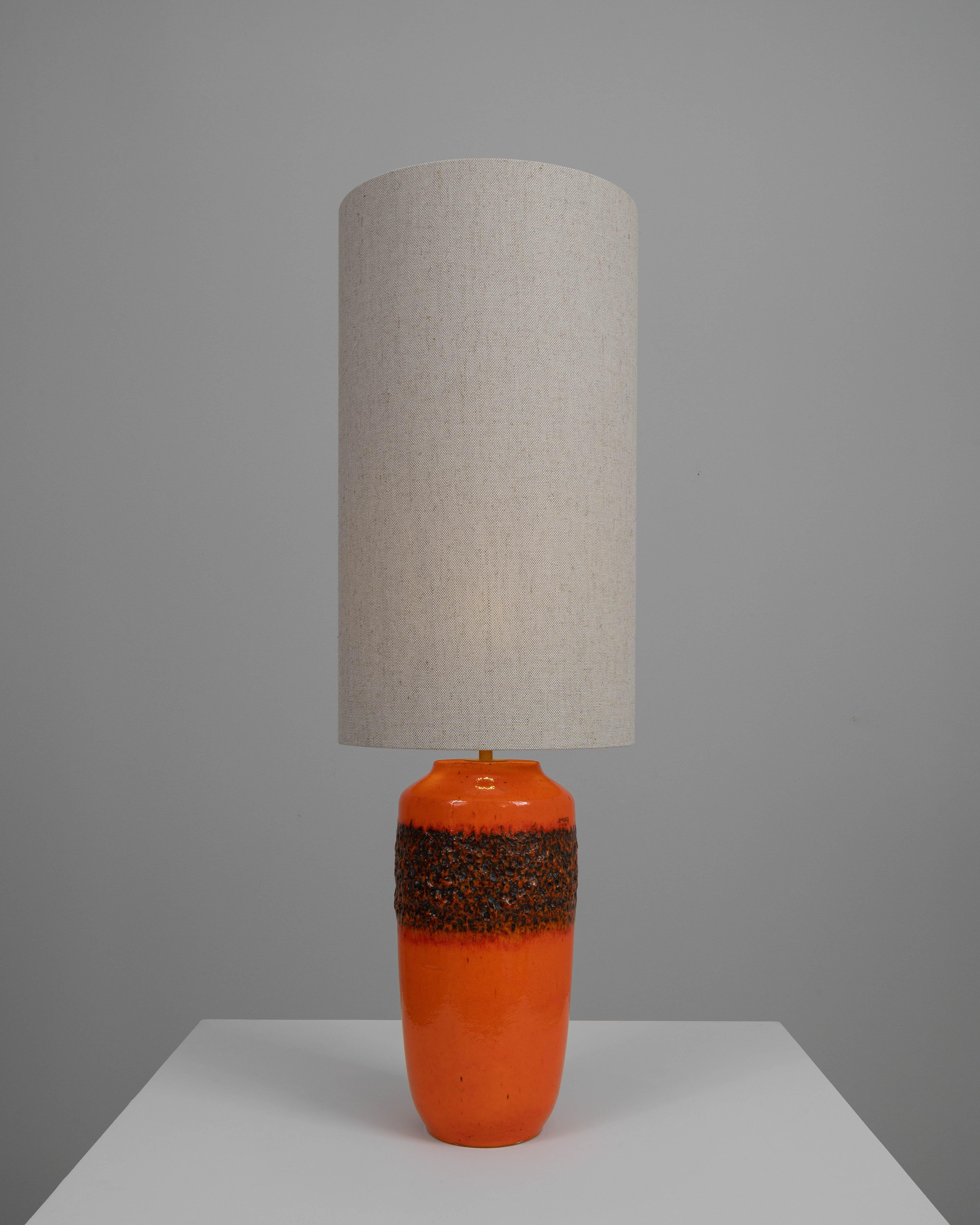 Ilumina tu espacio con un toque de elegancia vintage con esta lámpara de sobremesa de cerámica británica de principios del siglo XX. Su vibrante esmalte naranja y su sección central texturizada crean un llamativo contraste, convirtiéndola en una