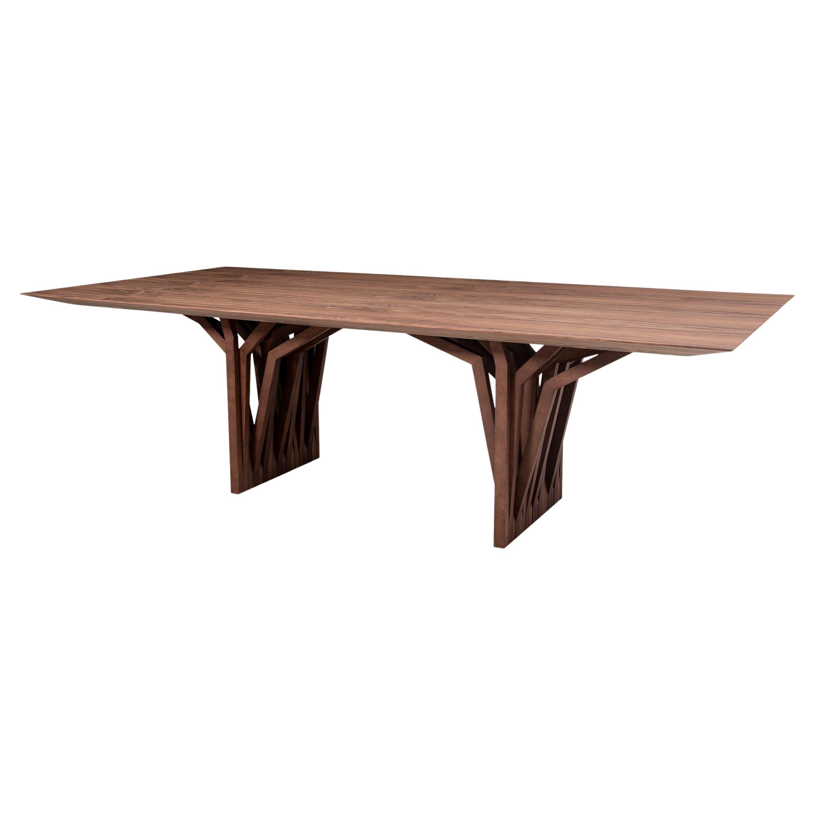 La table de salle à manger Radi est un chef-d'œuvre avec un plateau en placage de bois finition noyer et une base de table originale en forme d'ancre de toit, inspirée par les racines aériennes des arbres. Cette table de salle à manger est une pièce