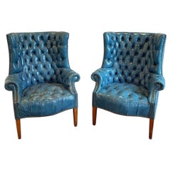 Paire de fauteuils à oreilles en cuir capitonné bleu, style milieu du siècle