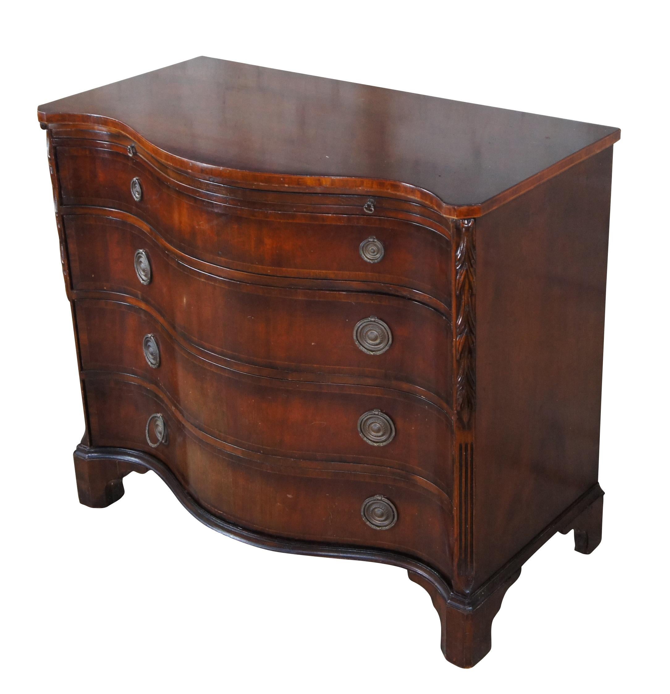 An exceptional Bachelors Chest, Buffet or Dresser by Union National, Circa 1940s.  Designed in George III styling with a dramatic serpentine mahogany case featuring four sliding dovetailed drawers and a pull out tray for service.  The chamfered