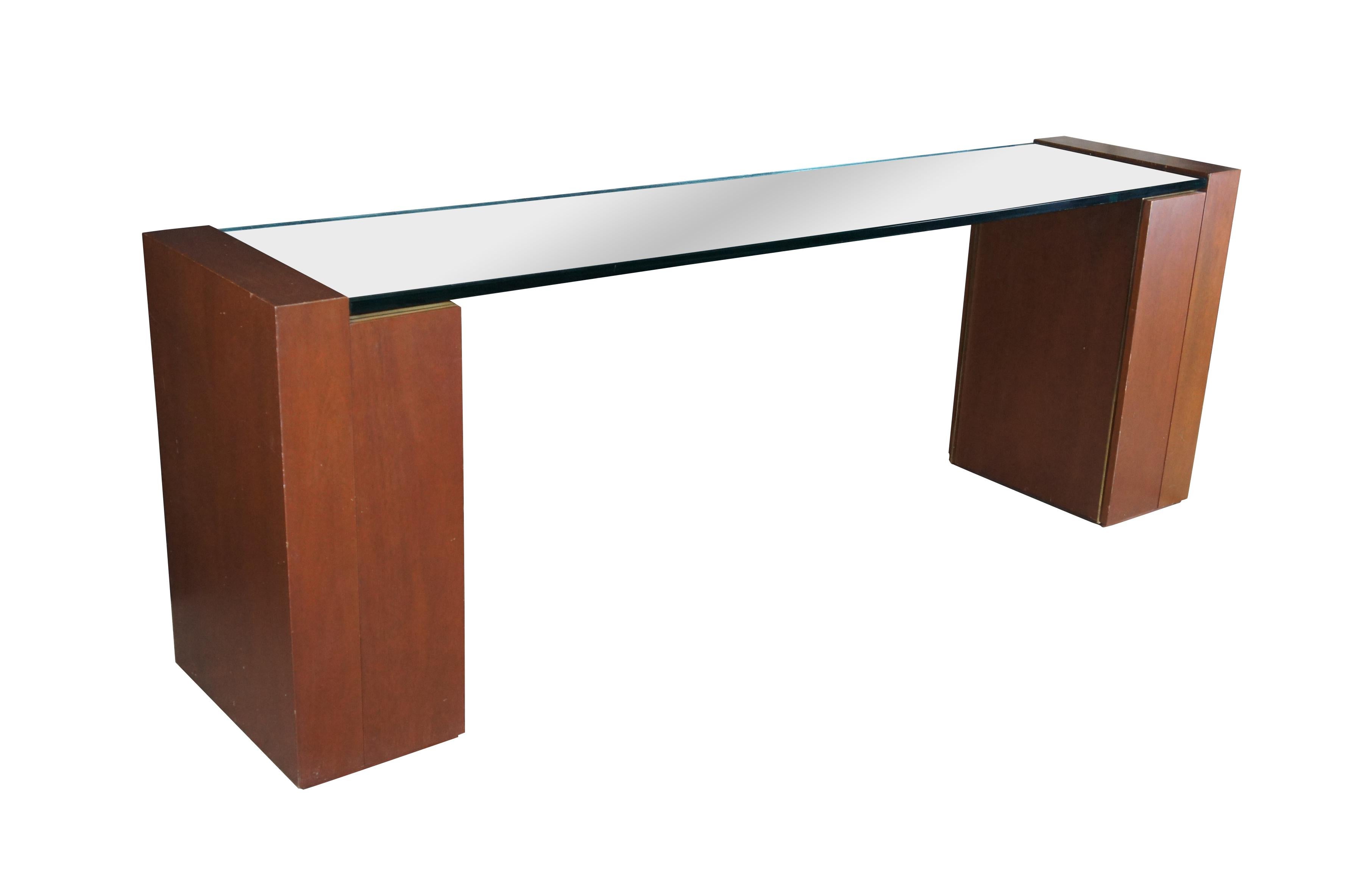 1980s Post Modern Console, Sideboard, Server or Drybar.  Features a large pencil polished glass surface centered between two mahogany pedestals.  Each pedestal is trimmed in brass along the top and insides

Dimensions:
92
