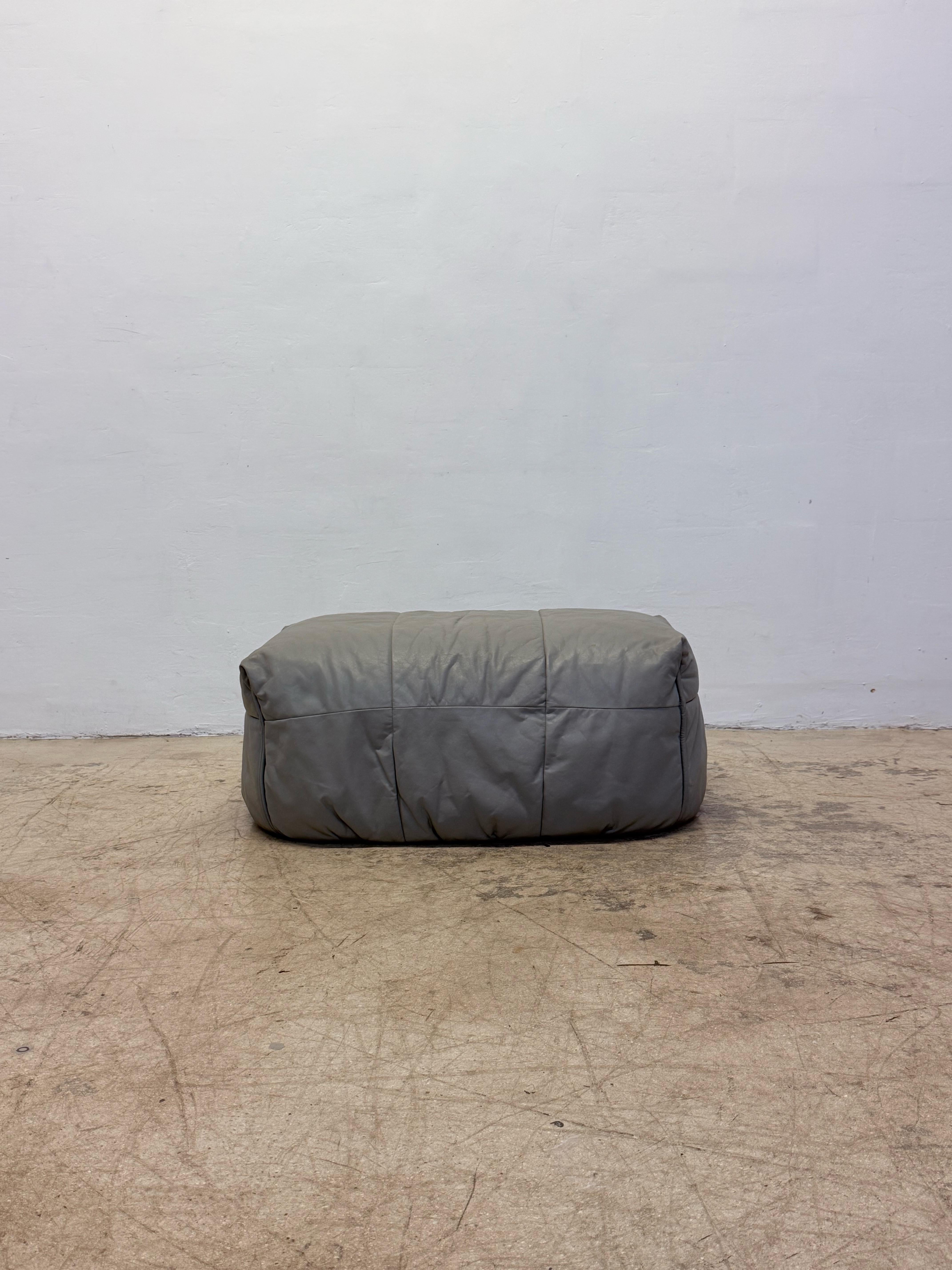 Pouf o poggiapiedi in pelle grigia vintage per la serie di divani Brigantin di Michel Ducaroy per Ligne Roset, anni Settanta.  Conserva l'etichetta e le marcature di Ligne Roset sul lato inferiore.