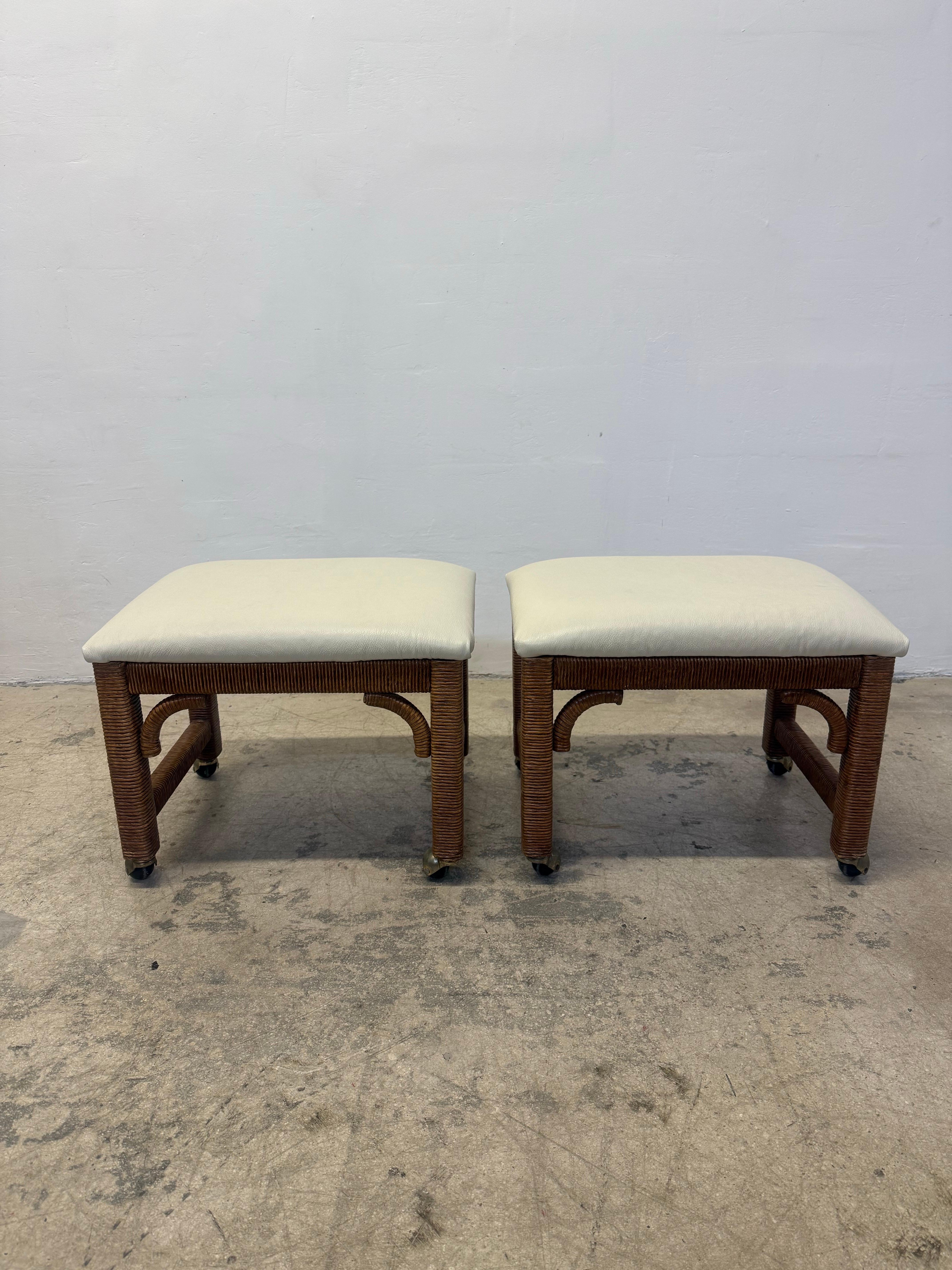 Pair of mid-century Henry Link rattan wrapped footstools on casters with off-white leather cushions circa 1960s.