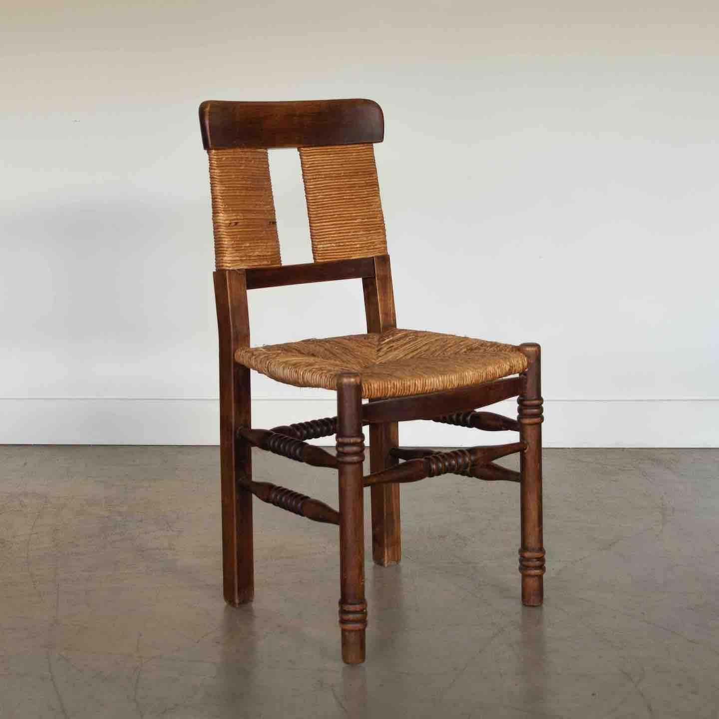 Beautiful carved wood chair from France, 1940s. Original woven rush back and seat. Intricate carved wood detail on legs and wood frame with medium stain. Original finish shows great age and patina. Perfect as a desk or side chair. 