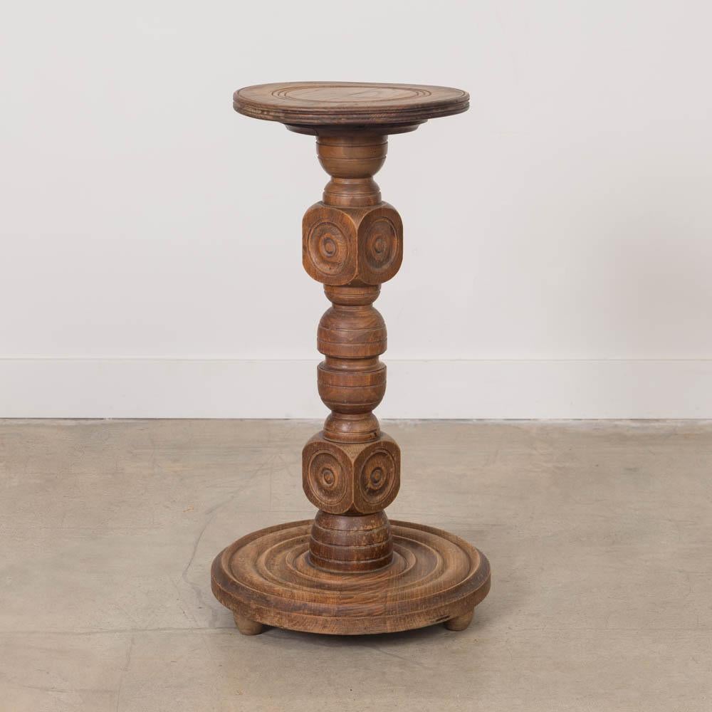 Wonderful carved wood pedestal table by Charles Dudouyt, made in France, 1940s. Thick carved wood block stem with circular top and base. Base has etched ring detail and rests on three rounded feet. Original wood finish shows nice age and patina with