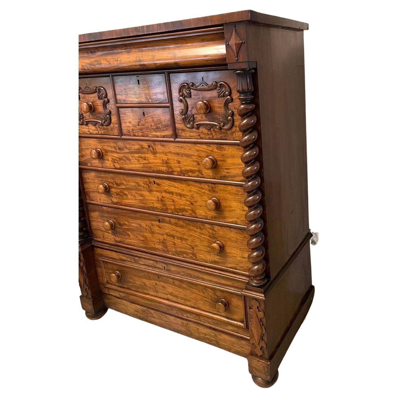 Outstanding quality antique Victorian Scottish figured mahogany chest of drawers having a polished mahogany top above a long shaped frieze drawer, two small centre drawers flanked by two quality carved drawers with original turned mahogany knobs,