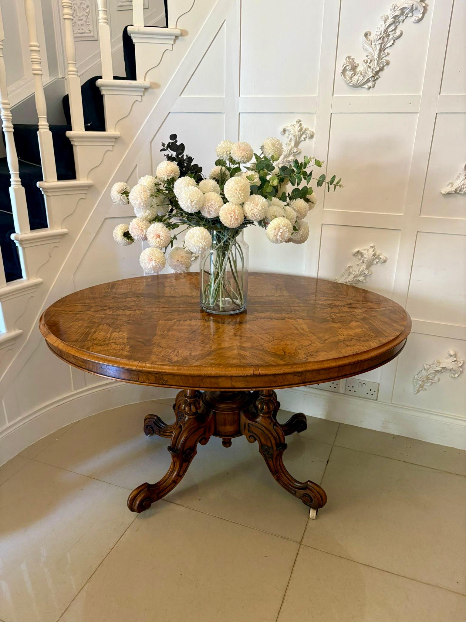 Antique Victorian quality burr walnut oval centre/dining table having a quality burr walnut oval tilt top with a moulded edge supported by four turned reeded carved solid walnut columns standing on shaped carved cabriole legs with scroll feet and