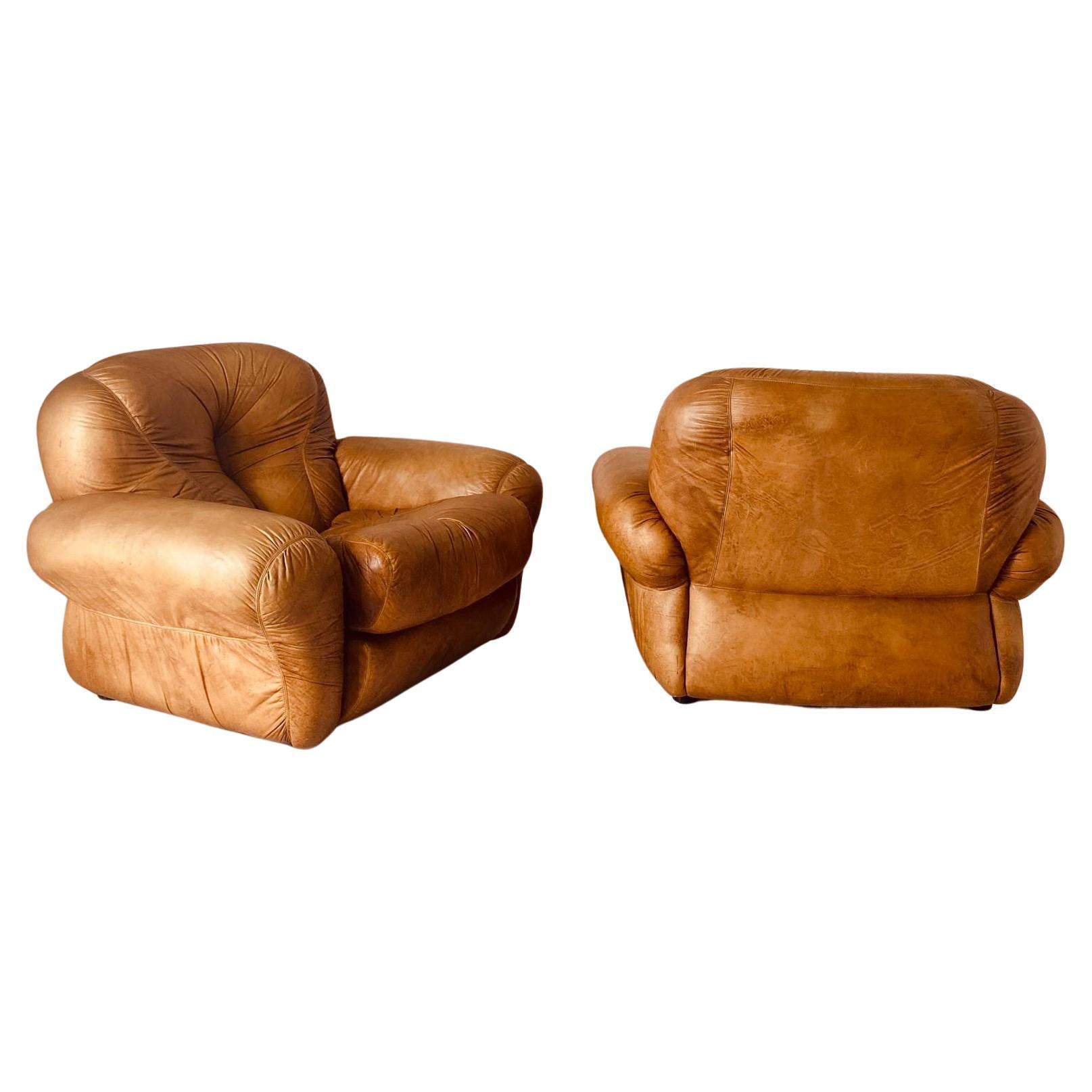 1970s vintage Cognac Brown leather Armchair, set of two, designed by SAPPORO for Mobil Girgi. 

Stylish and well proportioned lounge chairs that feature round lines and shapes that ensure super confort and relax. Easy to be used for both home and