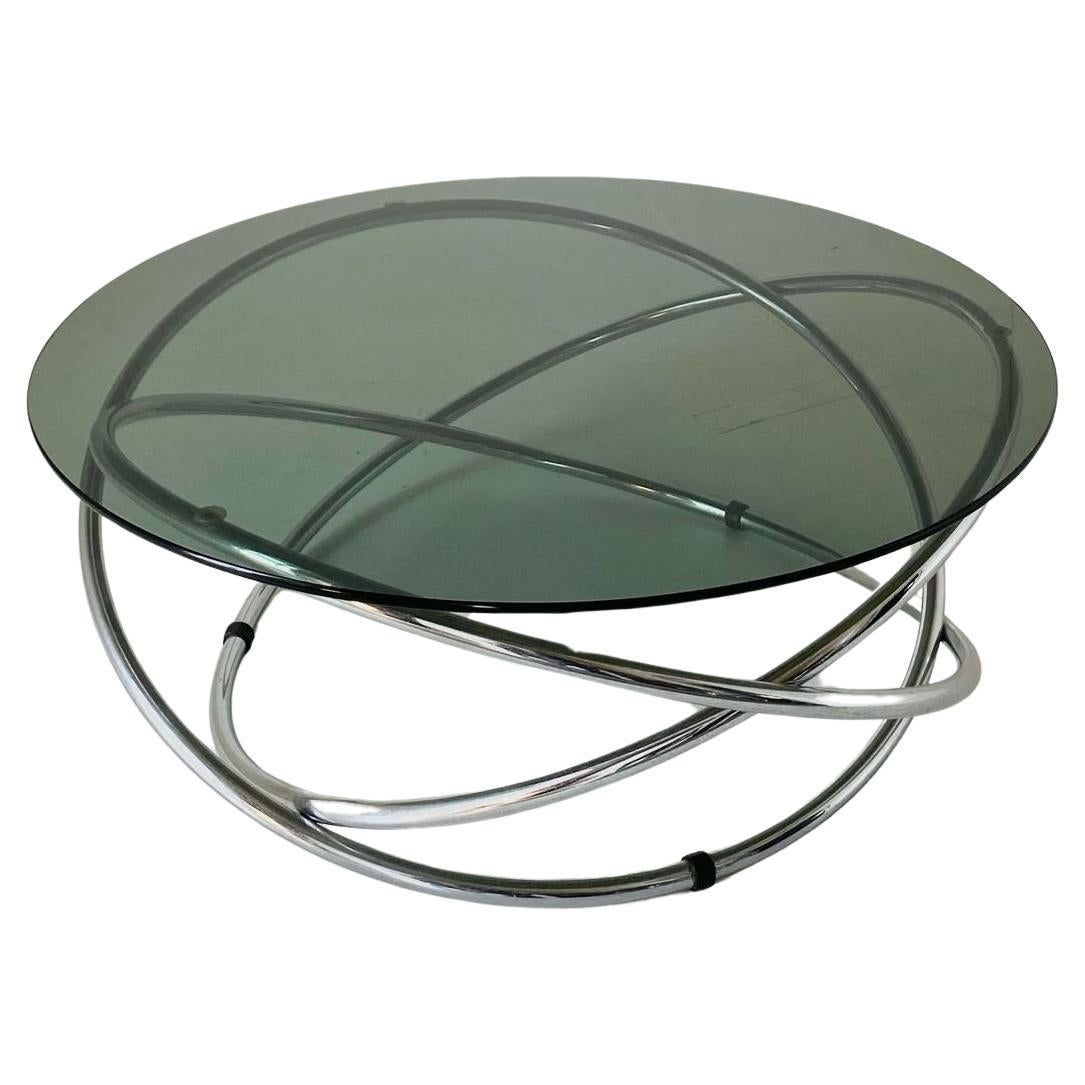 A vintage chromed coffee table with Smoked glass Top.
Pure made in Italy space age style from the 1970s. 
A mid- century round coffee table with beautifully designed chromed structure and smoked round black top. Very sturdy structure.
The item