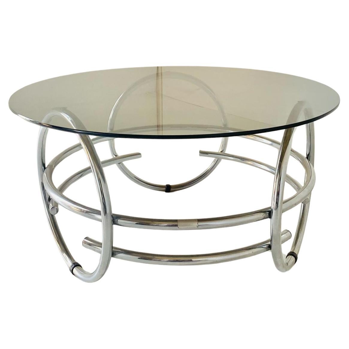 Vintage chromed coffee table with smoked glass top.
Pure space age style made in Italy from the 1970s. 
Mid-century round coffee table with chrome frame and smoked black top. Very sturdy structure.
The object represents the typical space age made in