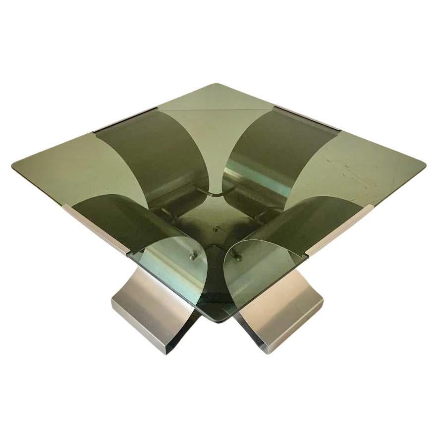 Tavolino da salotto  degli anni 70 ideato da Francois Monnet in Francia negli anni Settanta.

Il tavolo è composta da una struttura in acciaio inossidabile spazzolato e curvato, mentre il ripiano di forma quadrangolare è composto da un vetro fumé