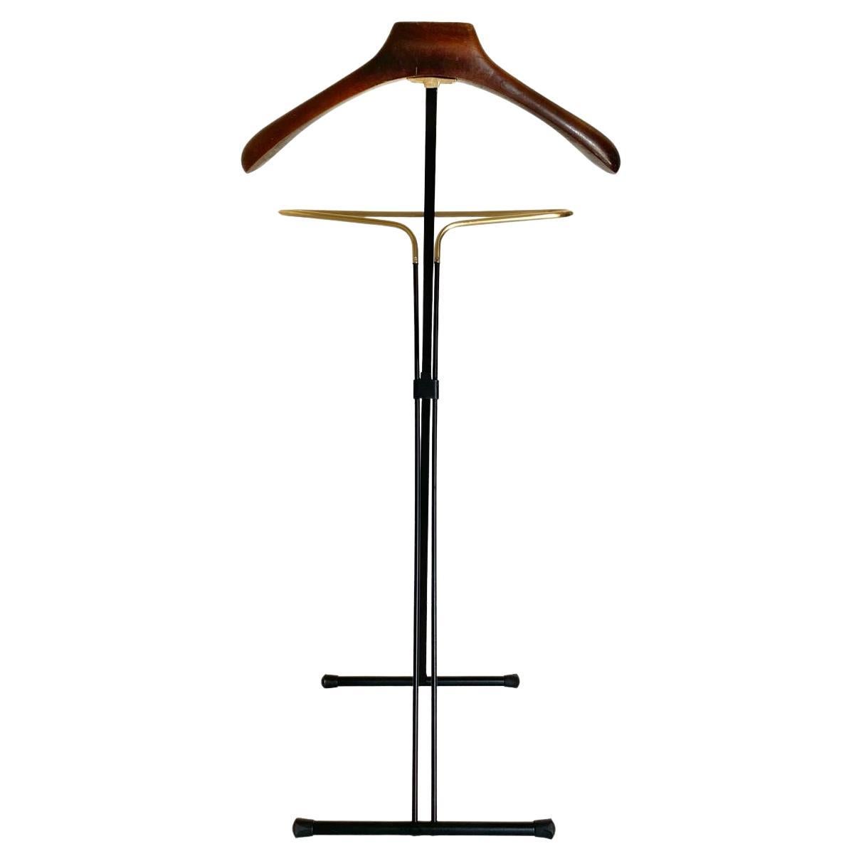 Charmy vintage valt stand manufactured in Italy in the 1950s by iconic Fratelli Reguitti company.  Folding valet with beech wood hanger and refined iron and brass frame. Completely restored as follows:
Iron has been repainted by using its original