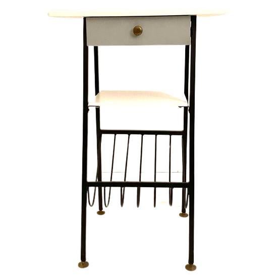 Cosy 1950s vintage console table manufactured in Italy in the 1950s.

Black painted iron frame with cosy magazine/book rack. White/light blue top with a drawer. Brass feet. Restored and in very good conditions. with signs of time. 

International