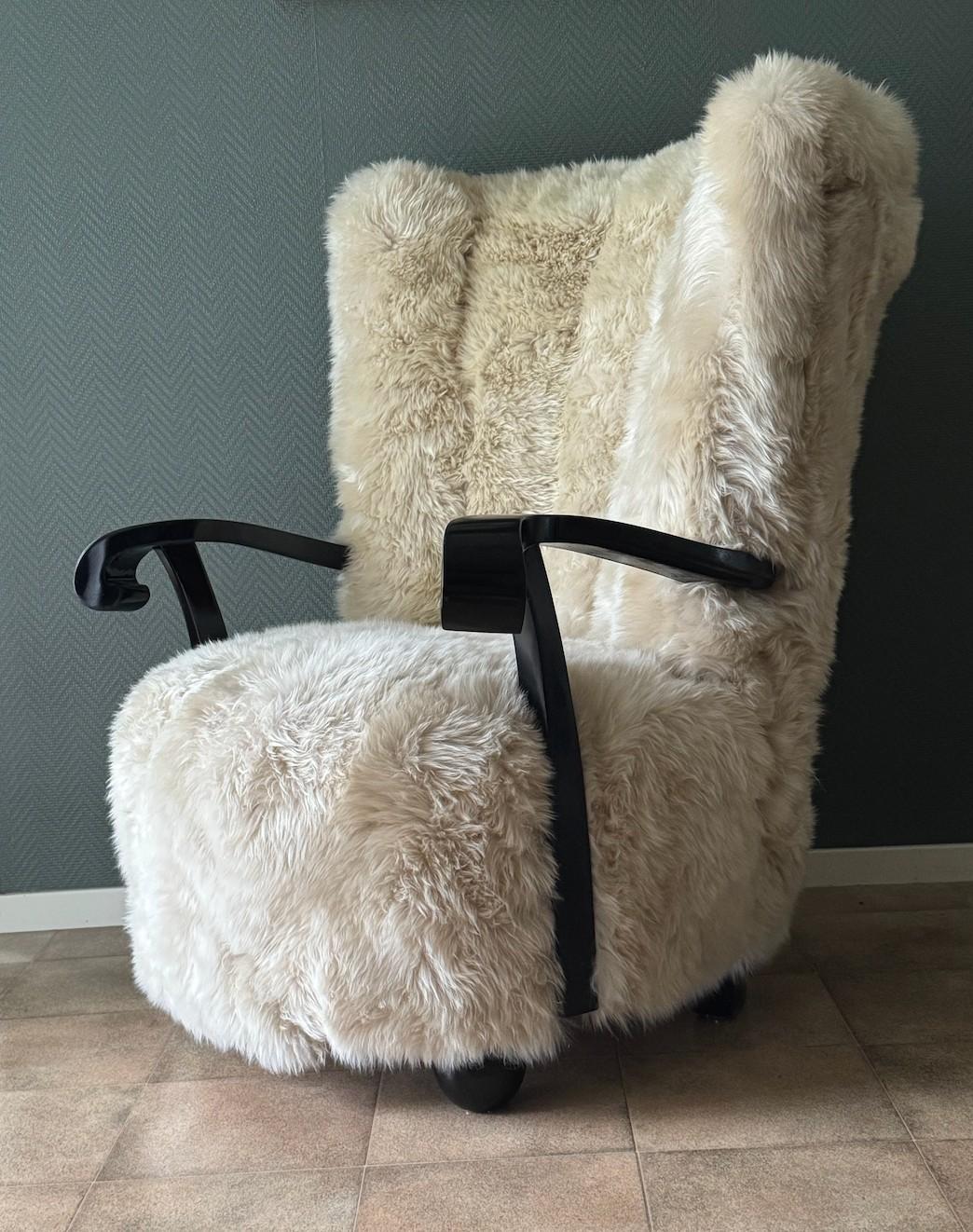 Un joli fauteuil Art Déco récemment retapissé en peau de mouton. La chaise est attribuée à Almgren & Sven Staaf et a probablement été conçue et produite à Helsingborg, en Suède, en 1935. Sa surface est laquée noire et brillante. La hauteur de la