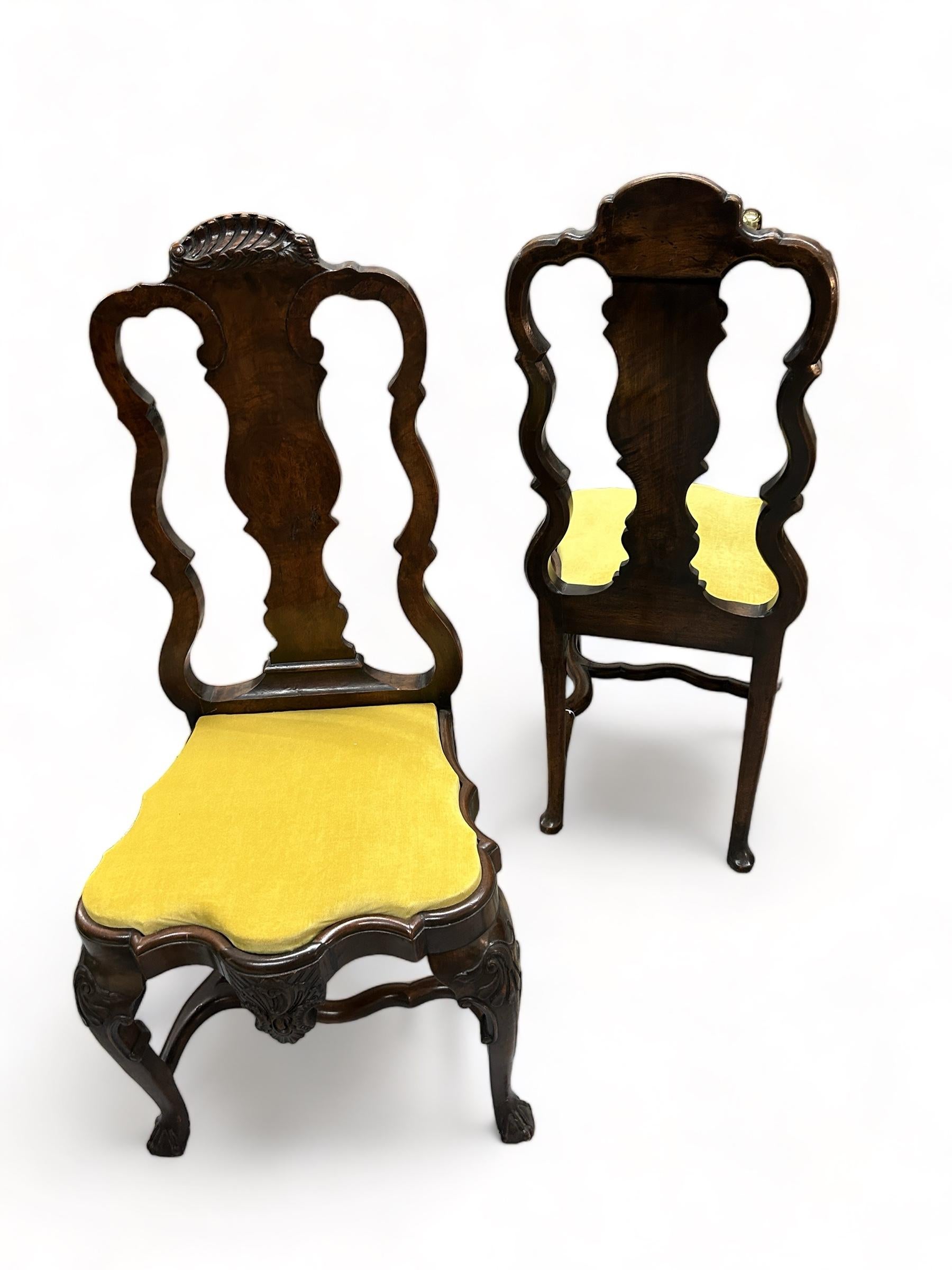 Merveilleuse paire de chaises d'appoint hollandaises du XVIIIe siècle lourdement sculptées. Les deux chaises sont ornées de sculptures de coquillages dans les traverses de la crête. Les genoux sont sculptés de motifs d'acanthes d'inspiration rococo