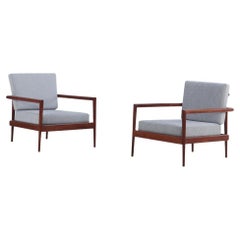 A pair of lounge chairs with Windsor backs designed by Edmund Spence.