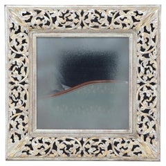 A silver gilt carved wood square mirror.
