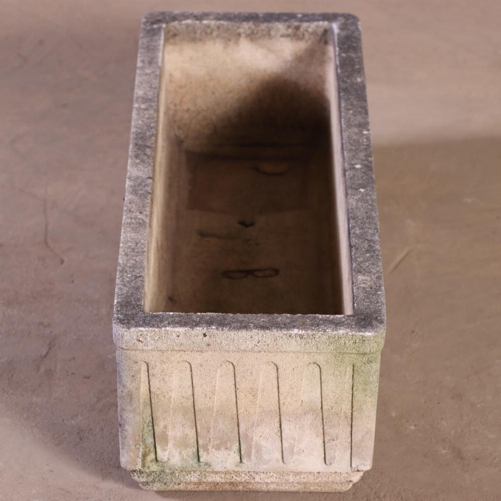 A distinctive pair of French cast stone planters, circa 1950, bearing the mark Grandon Frès. These planters feature subtle Art Deco styling, with clean lines and restrained geometric detailing. The cast stone surfaces have acquired a beautifully